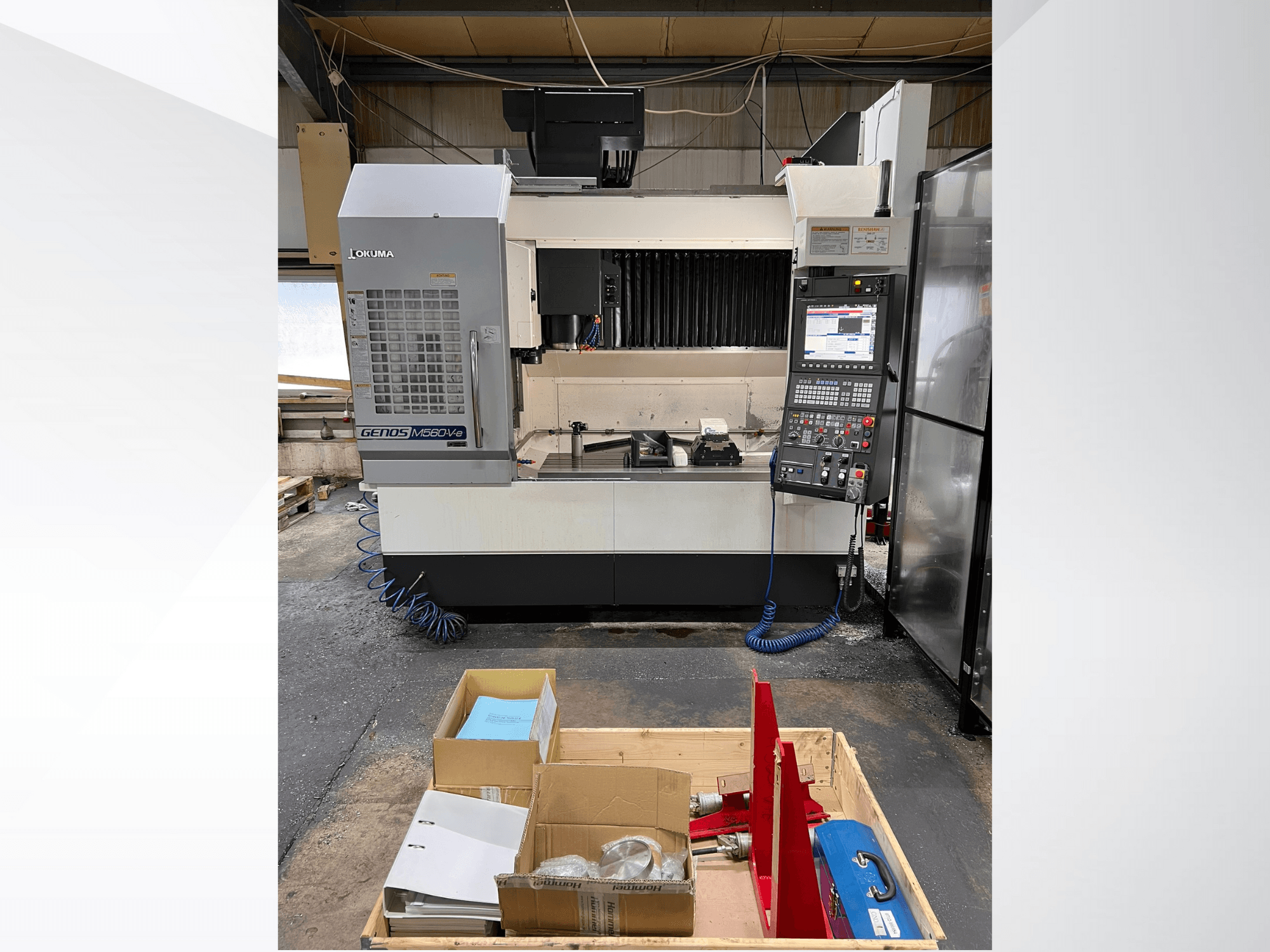 Centre d'usinage vertical Okuma GENOS M460V-5, vue de face, panneau de commande visible et outils sur la table de travail.