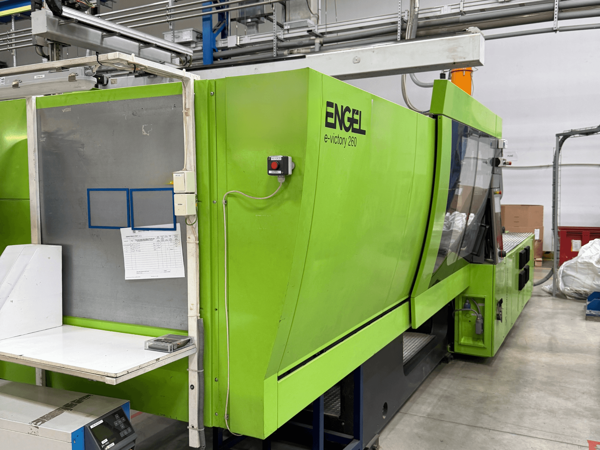 Vue de profil de la presse à injection électrique Green Engel e-victory 260, avec son panneau de commande et son plan de travail.