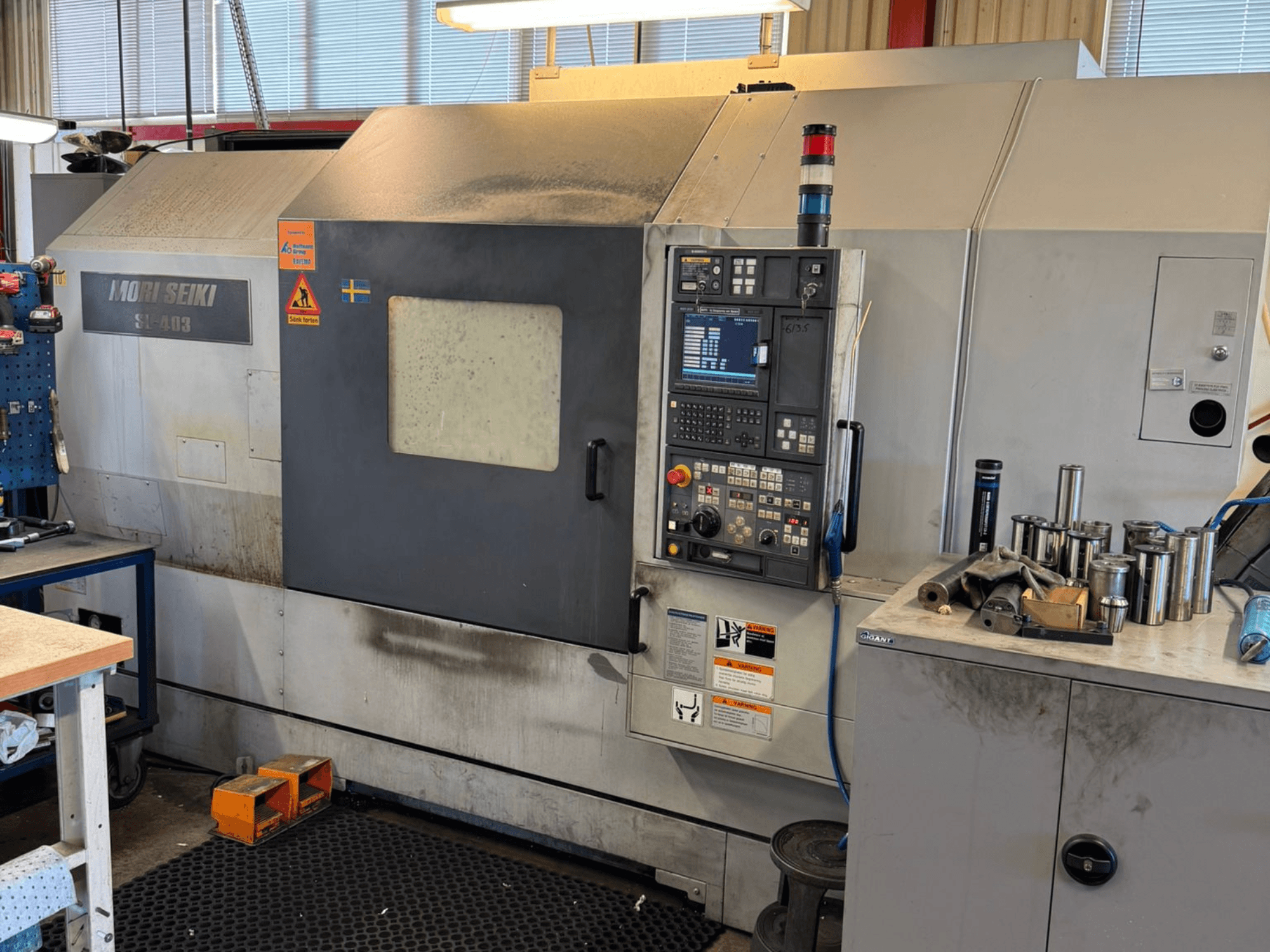Tour horizontal MORI SEIKI SL-403BMC/800 dans un atelier, montrant le panneau de commande et les outils à proximité, vue latérale.