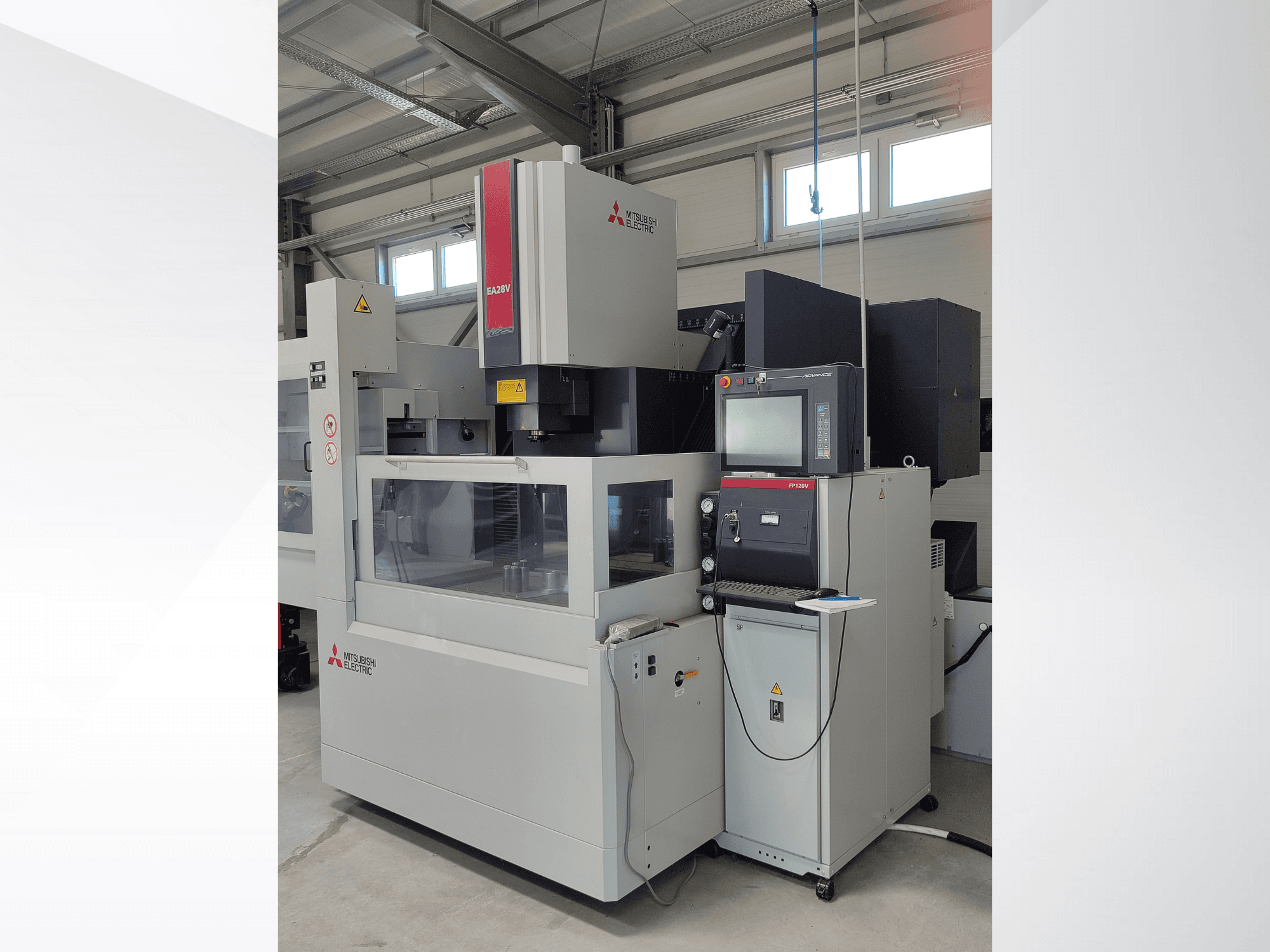 Machine d'électroérosion à fil EA32V de Mitsubishi Electric vue de côté, avec un panneau de commande et une zone de travail visible à travers la vitre.