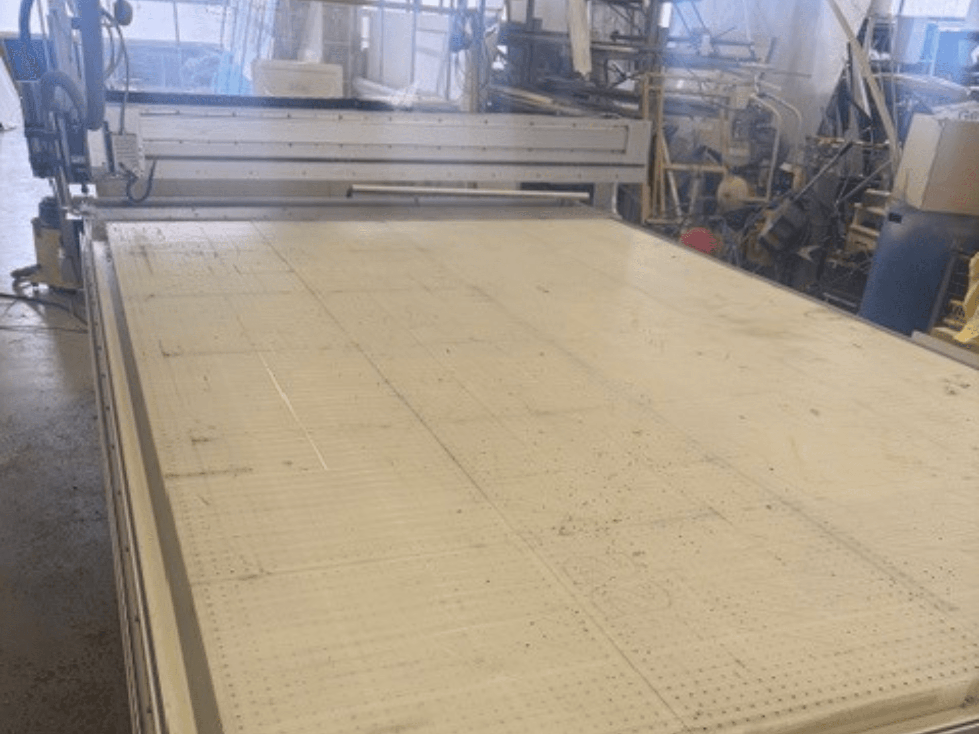 Grande machine à découper à surface plane, montrant le cadre et le rail de guidage ; vue d'un angle dans un atelier.