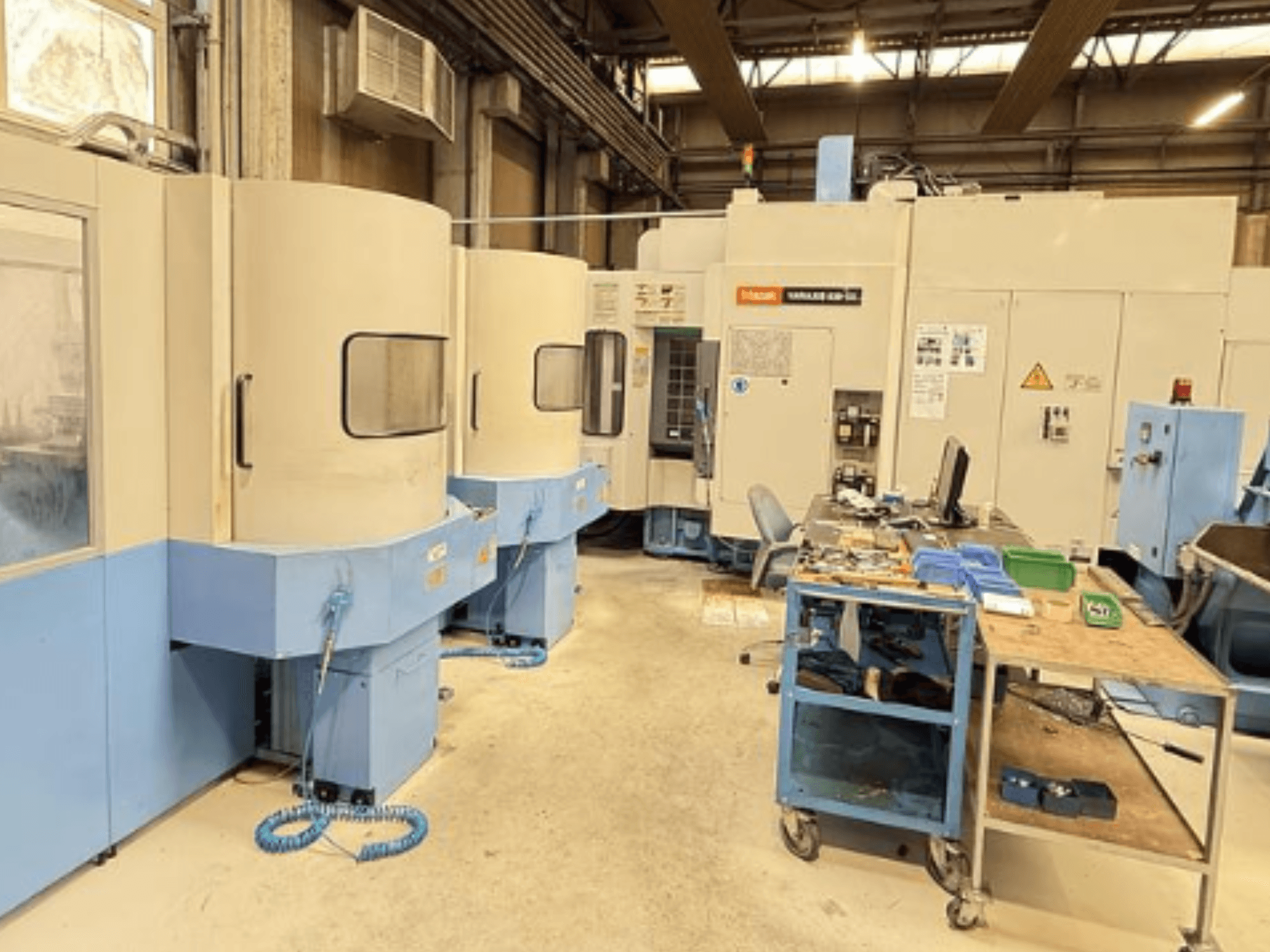 Centre d'usinage vertical Mazak Variaxis 630-5X dans un atelier, vue de face montrant le panneau de commande et la zone de stockage des outils.