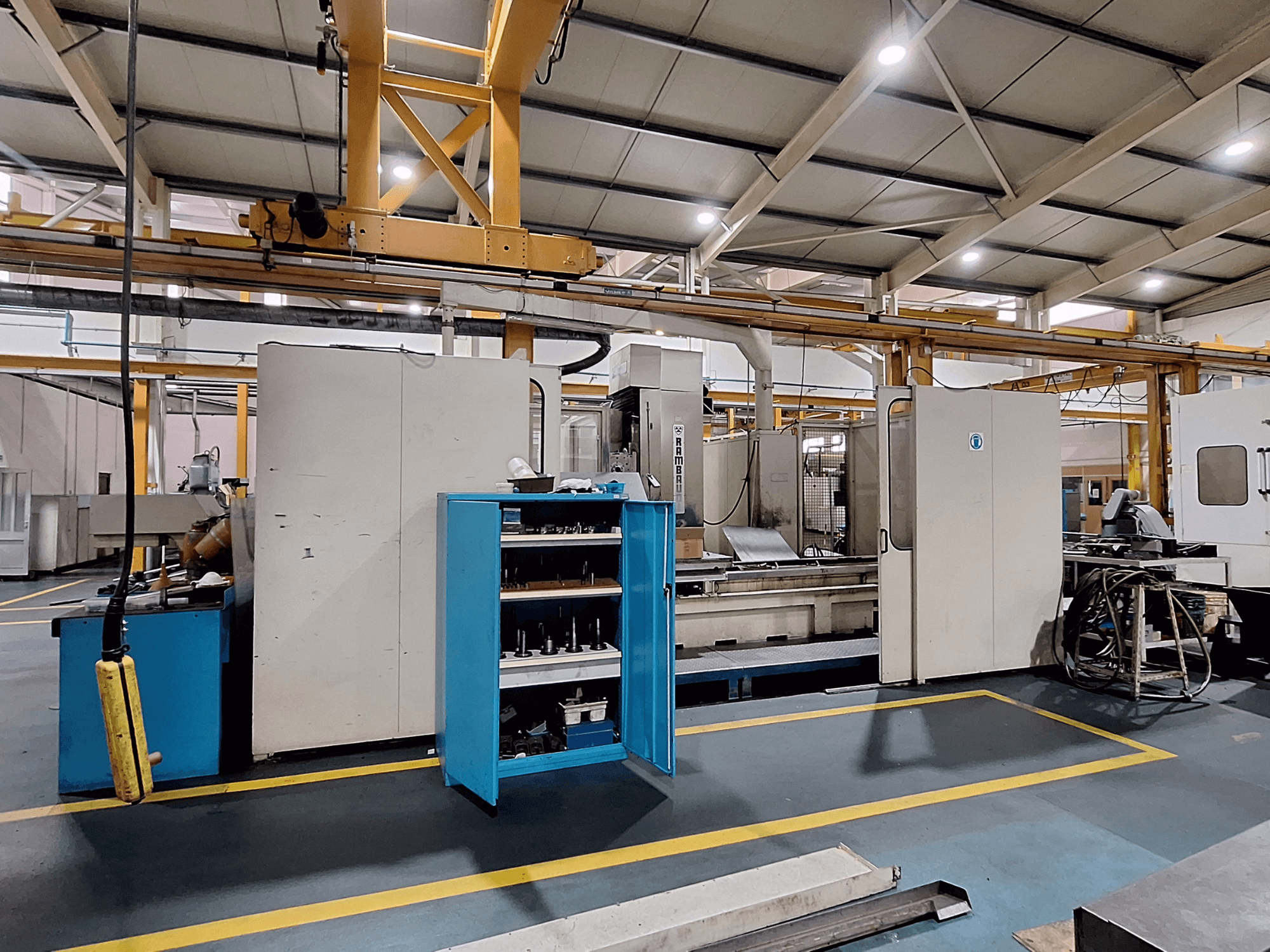 Fraiseuse à portique Rambaudi RX 1250, vue de face avec rangement des outils, dans un espace de travail industriel spacieux.