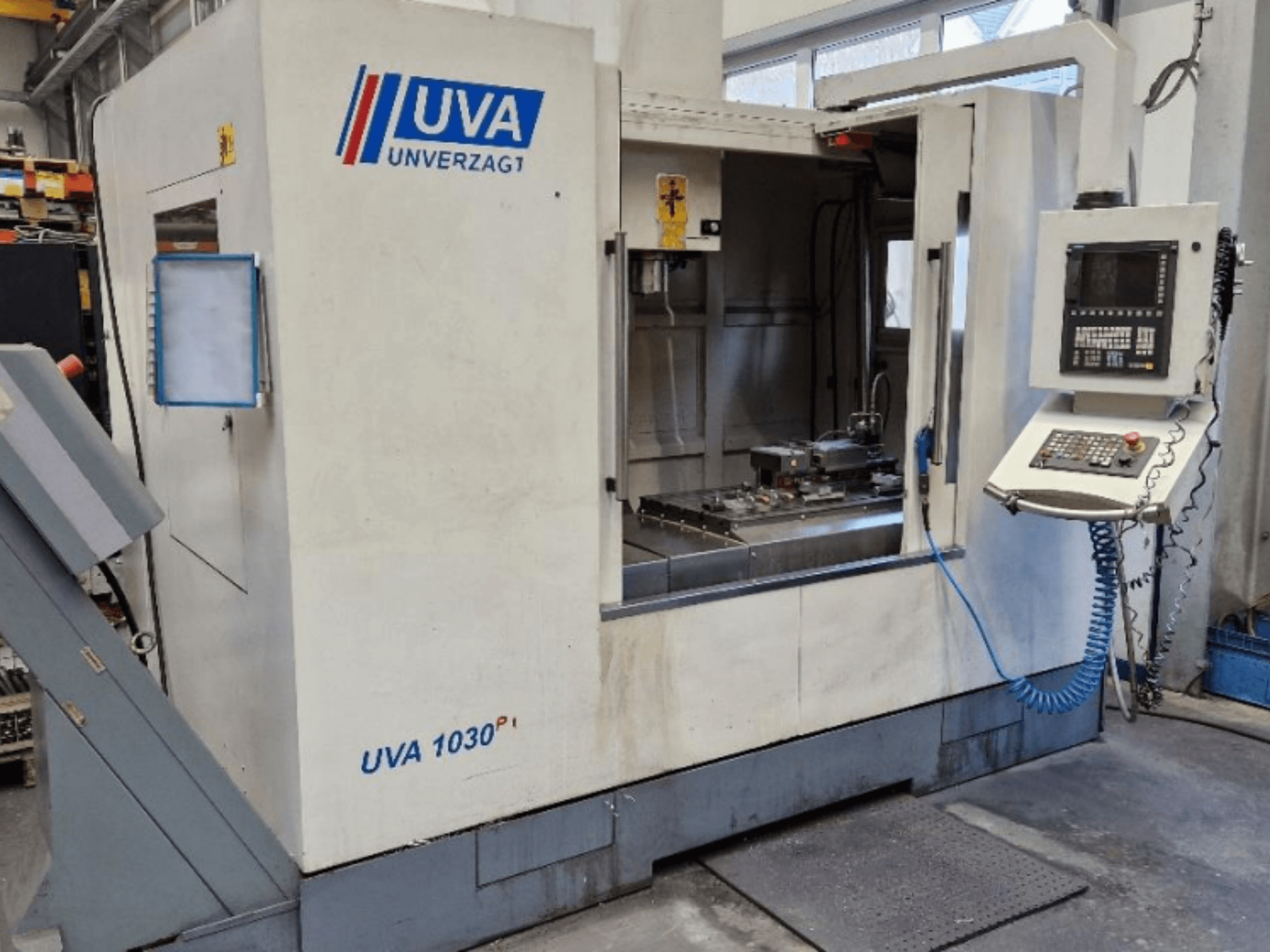 Machine-outil UVA 1030P dans un atelier, vue de face montrant le panneau de commande, la zone de travail et la surface de coupe propre.