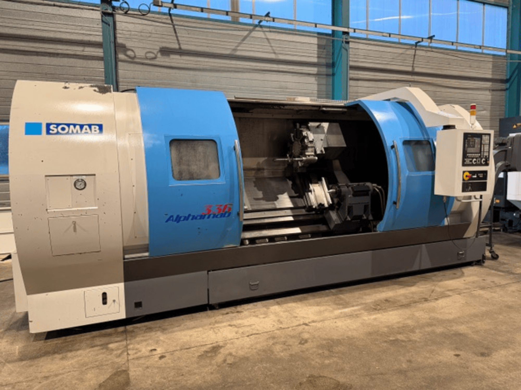 Tour CNC SOMAB Alpha 336, vue de face, avec boîtier bleu et gris et panneau de commande latéral.
