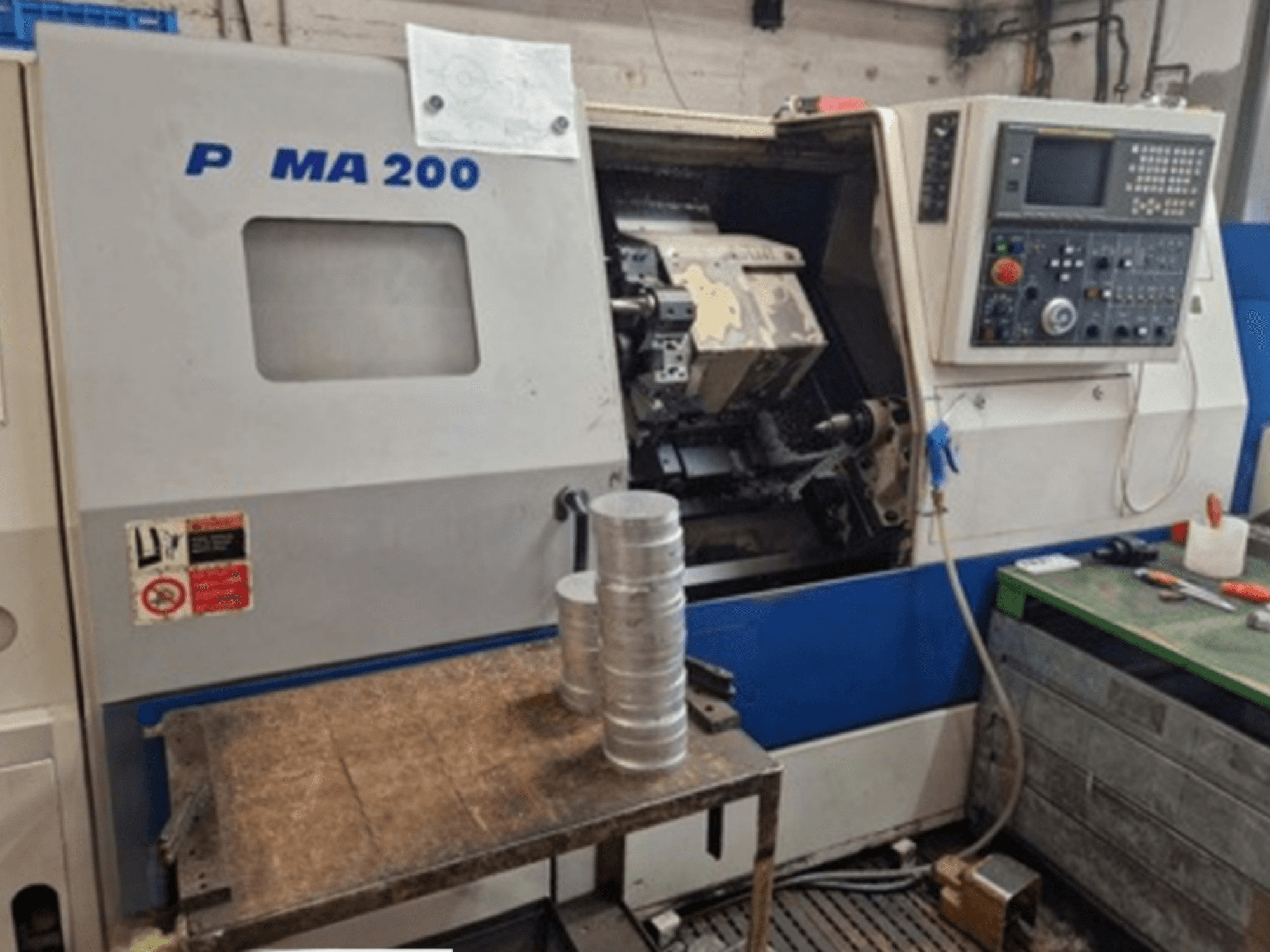 Tour horizontal DAEWOO EcoTurn 200, vue de face, avec des pièces en aluminium sur une table, panneau de commande visible.