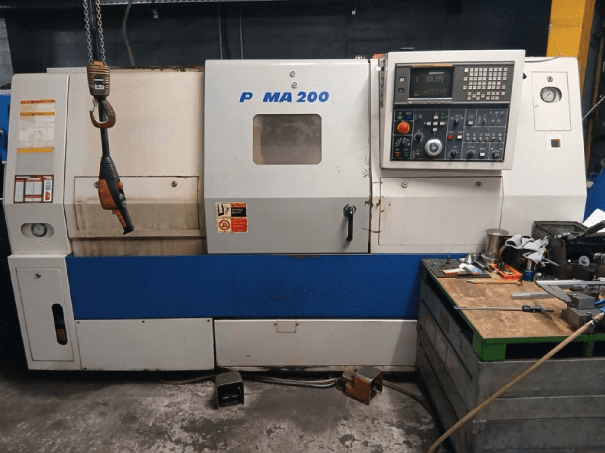 Vue de face du tour horizontal DAEWOO EcoTurn 200, avec le panneau de commande et les étiquettes de sécurité.