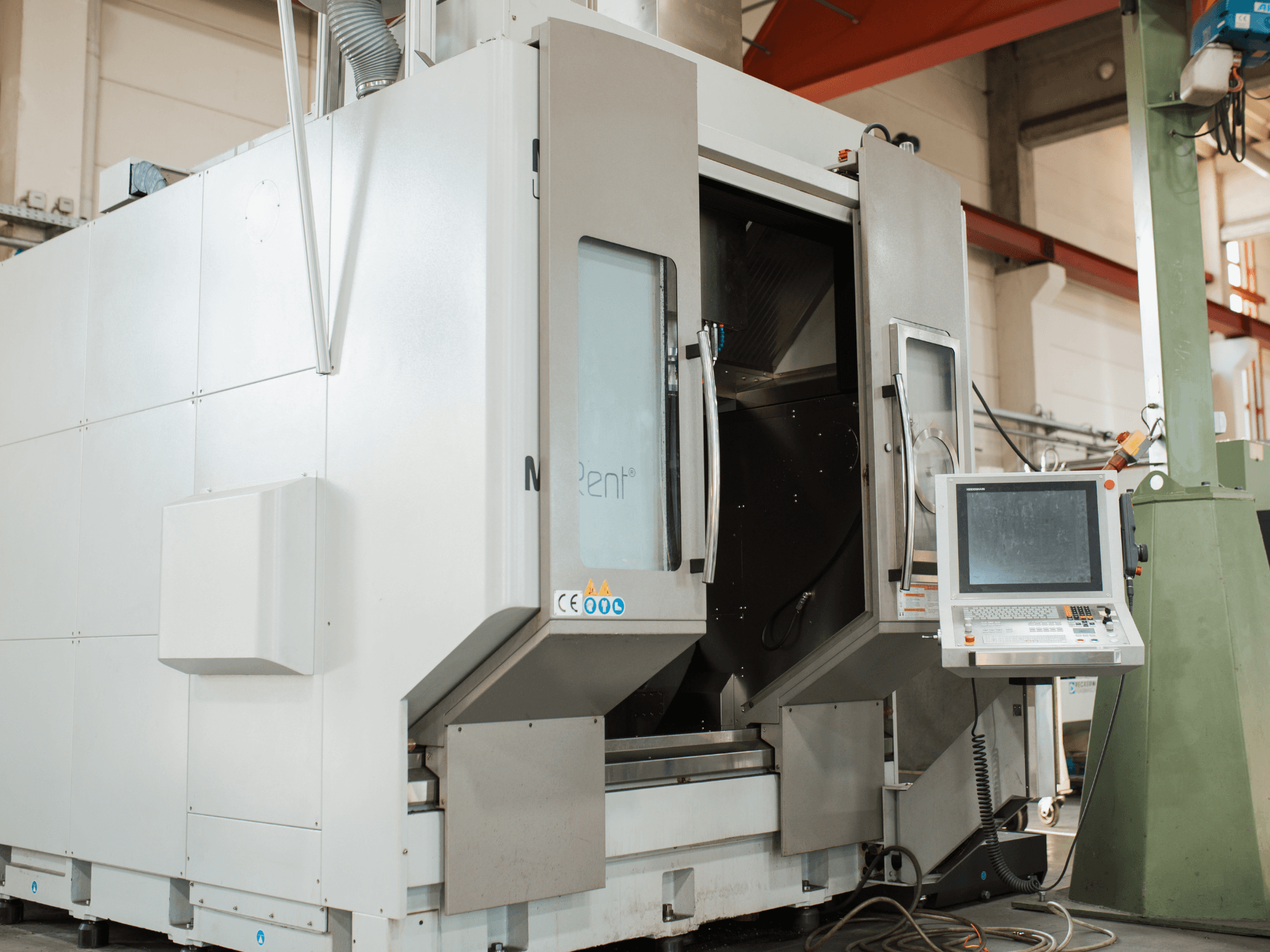 La fraiseuse CNC N Rent®, vue de face, présente un panneau de commande avec écran, des portes ouvertes et un environnement industriel.