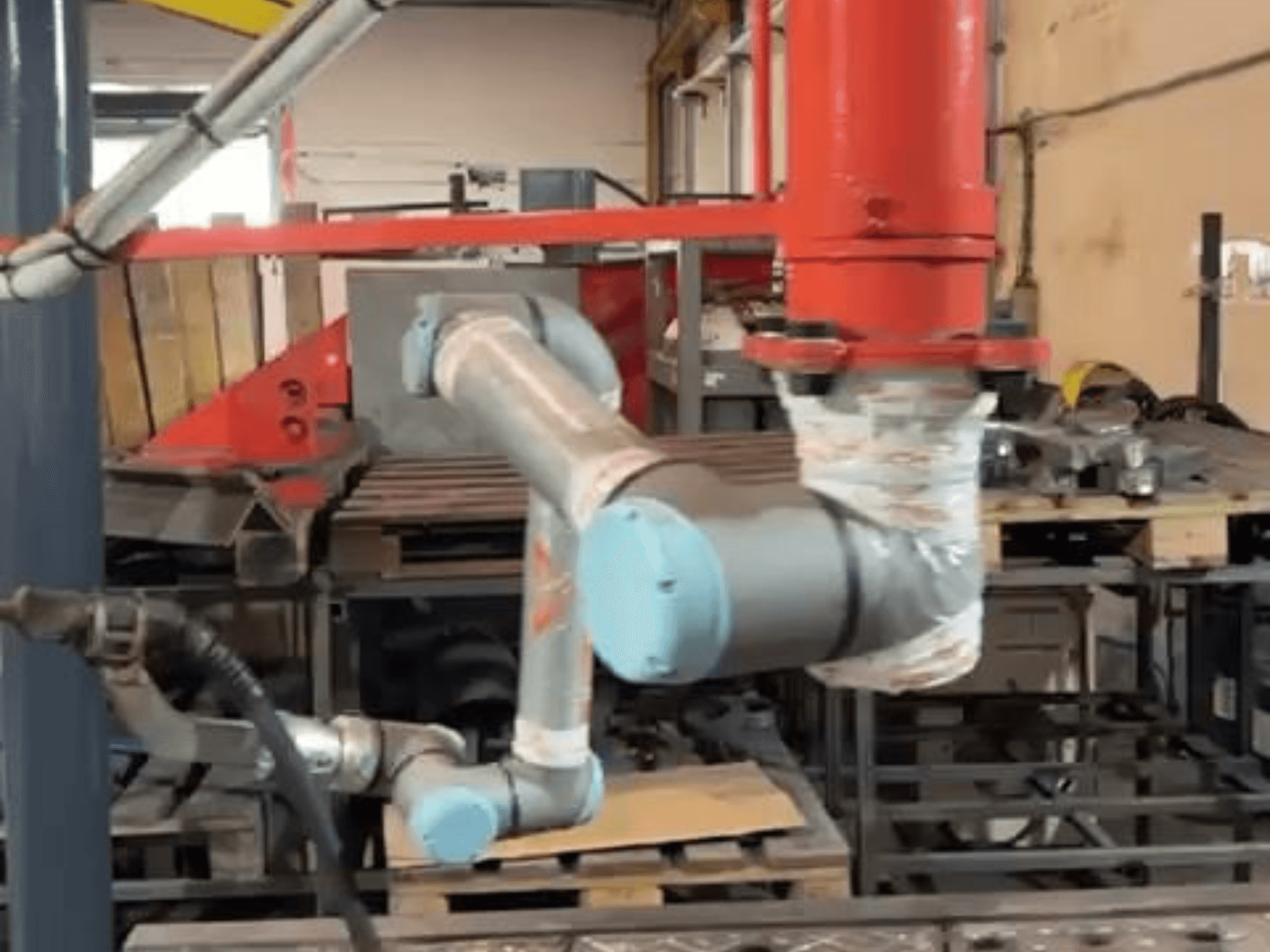 Robot collaboratif UR10e d'Universal Robots dans un atelier ; vue de profil montrant les mouvements du bras et des articulations à proximité des machines.
