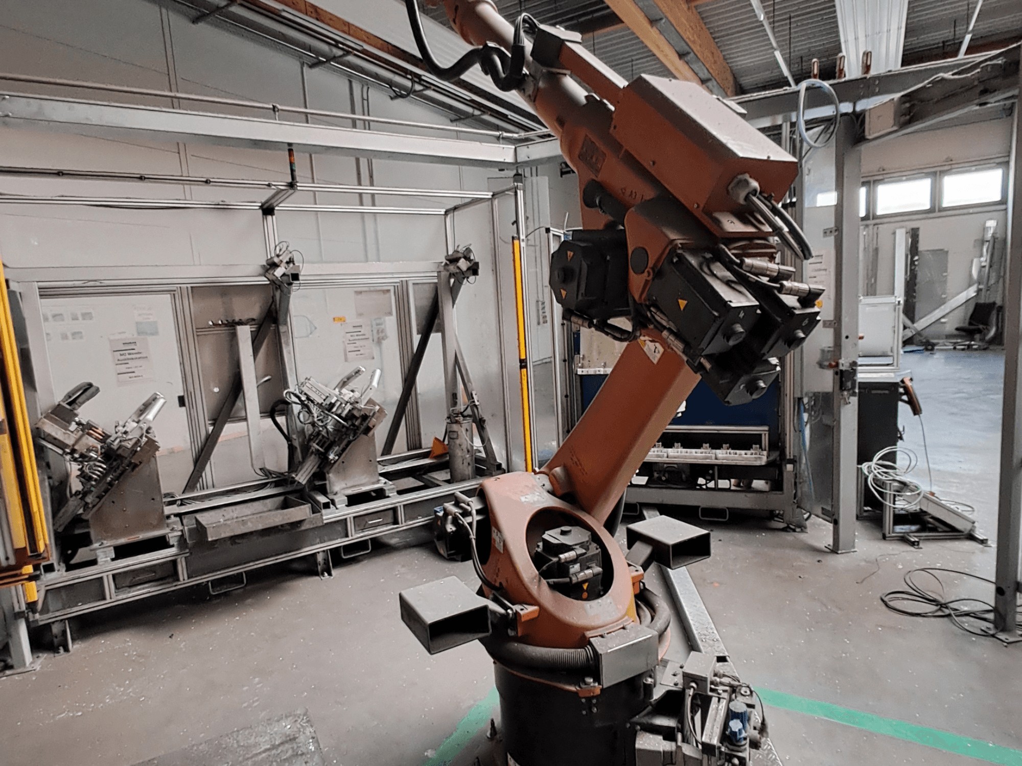 Bras robotisé KUKA KR 30L16-2 dans un environnement industriel, vue de profil, mettant en évidence les articulations du bras et ses outils de préhension.