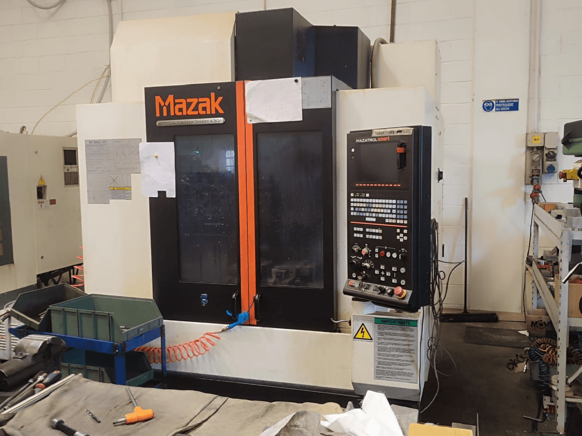Centre d'usinage vertical Mazak VCS 430A, vue de face montrant le panneau de commande et les détails opérationnels dans un atelier.