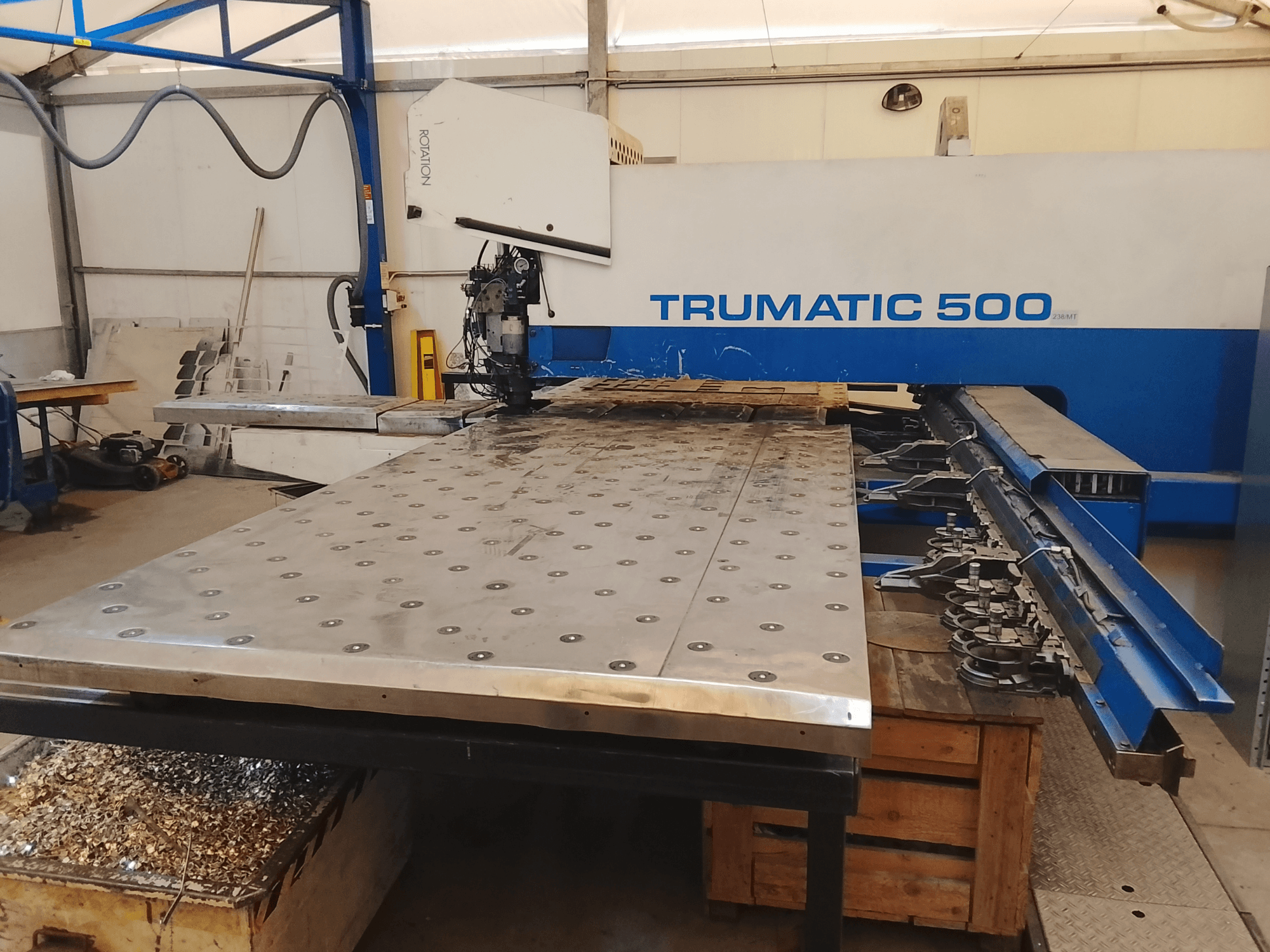 Machine CNC Trumatic 500, vue de dessus, comprenant une grande table de découpe de métal avec des outils montés et des copeaux en dessous.