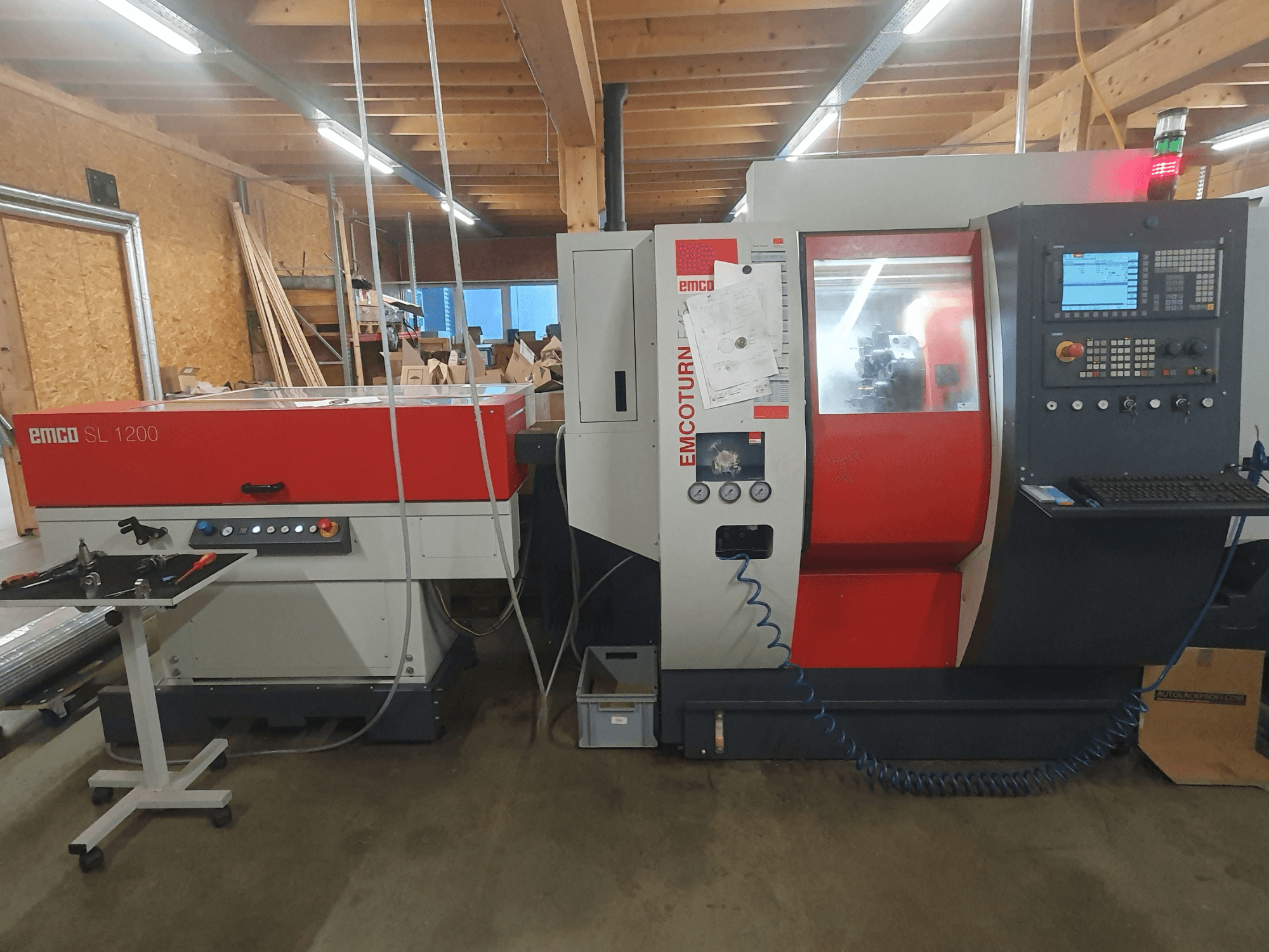 Tour CNC EMCO SL 1200 et EMCOturn ; vue de face montrant les commandes, les affichages et les indicateurs opérationnels dans un atelier.