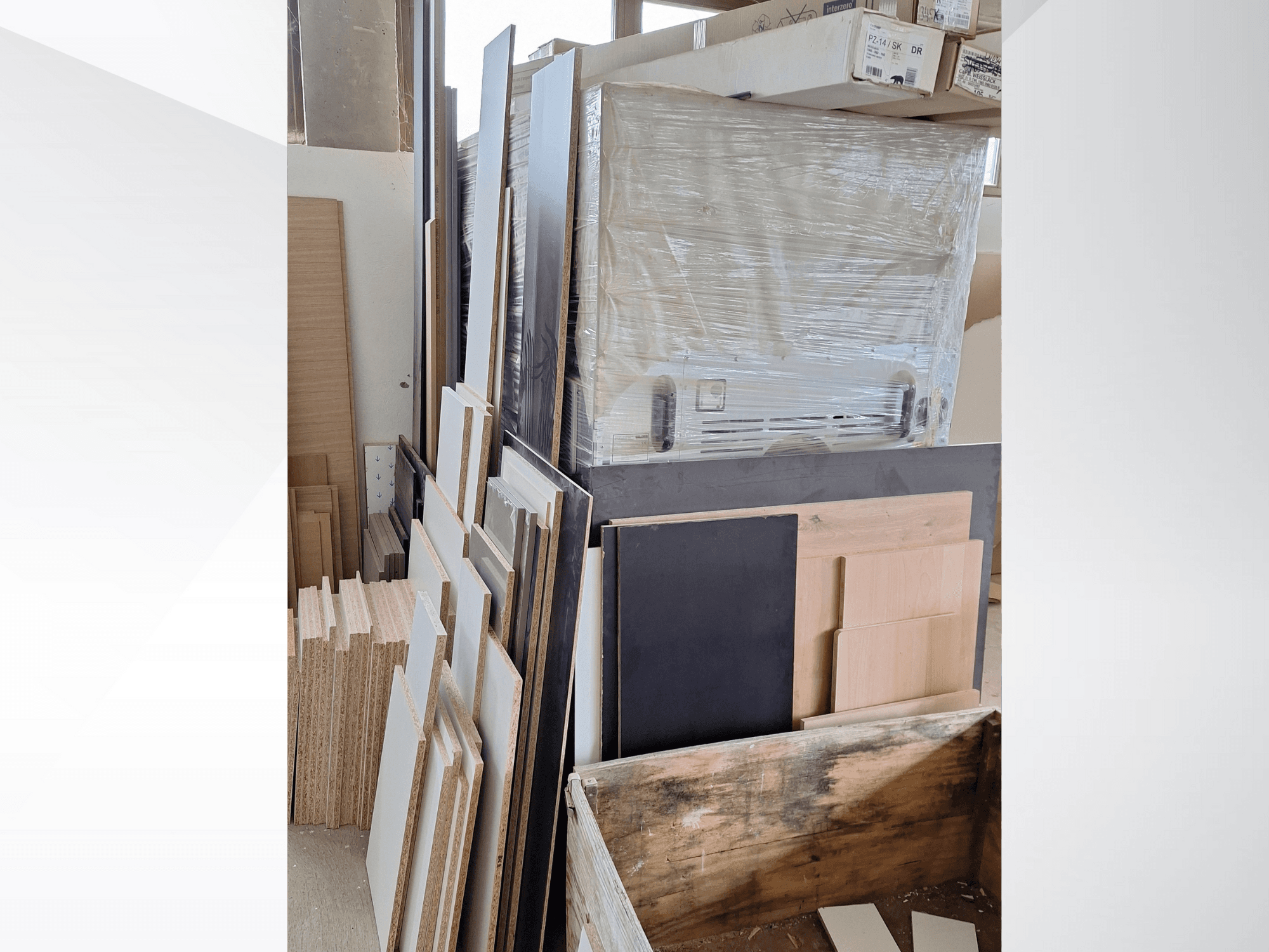 Panneaux de contreplaqué et planches empilés, présentant diverses finitions ; vue de face des matériaux dans un atelier.