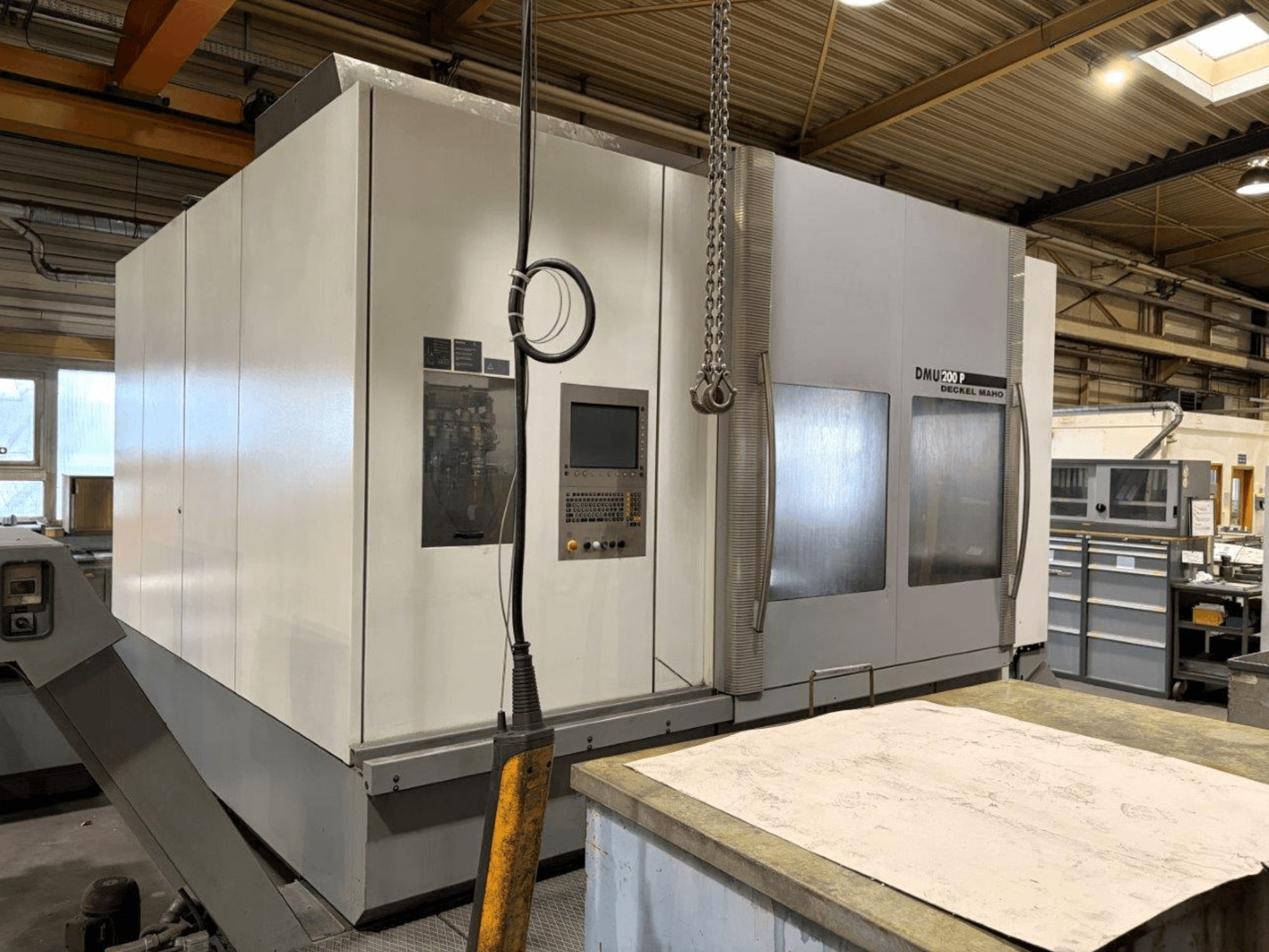 Centre d'usinage universel DMG MORI DMU 200 dans un atelier, vue de face, présentant son panneau de commande et ses caractéristiques extérieures.