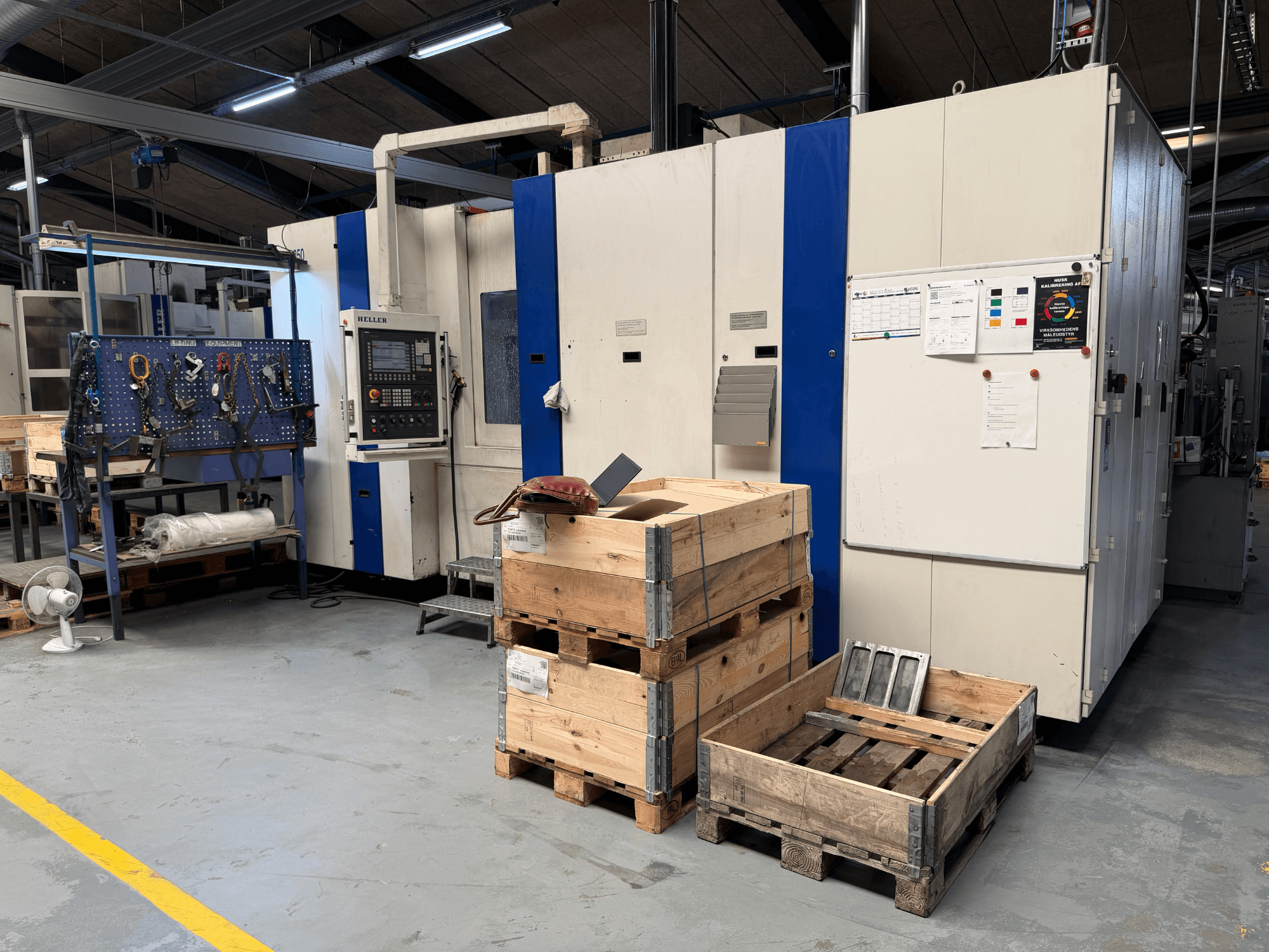 CENTRE D'USINAGE HORIZONTAL HELLER MCH 250 dans un atelier, vue latérale avec palettes en bois et porte-outils visibles.