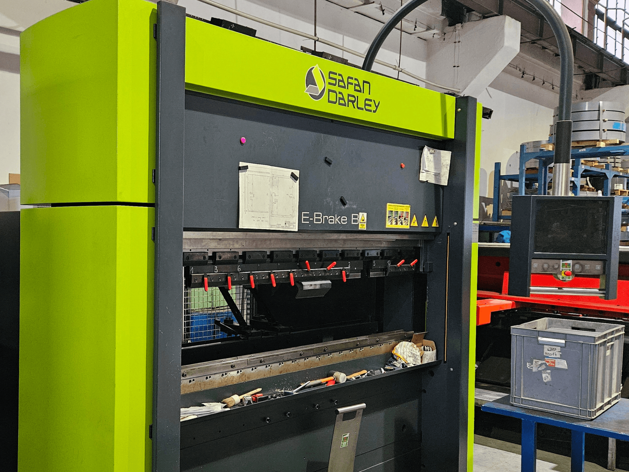 Plieuse SAFAN E-Brake B 50-2050 dans un atelier, avec les outils de serrage rouges et le panneau de commande visibles de face.