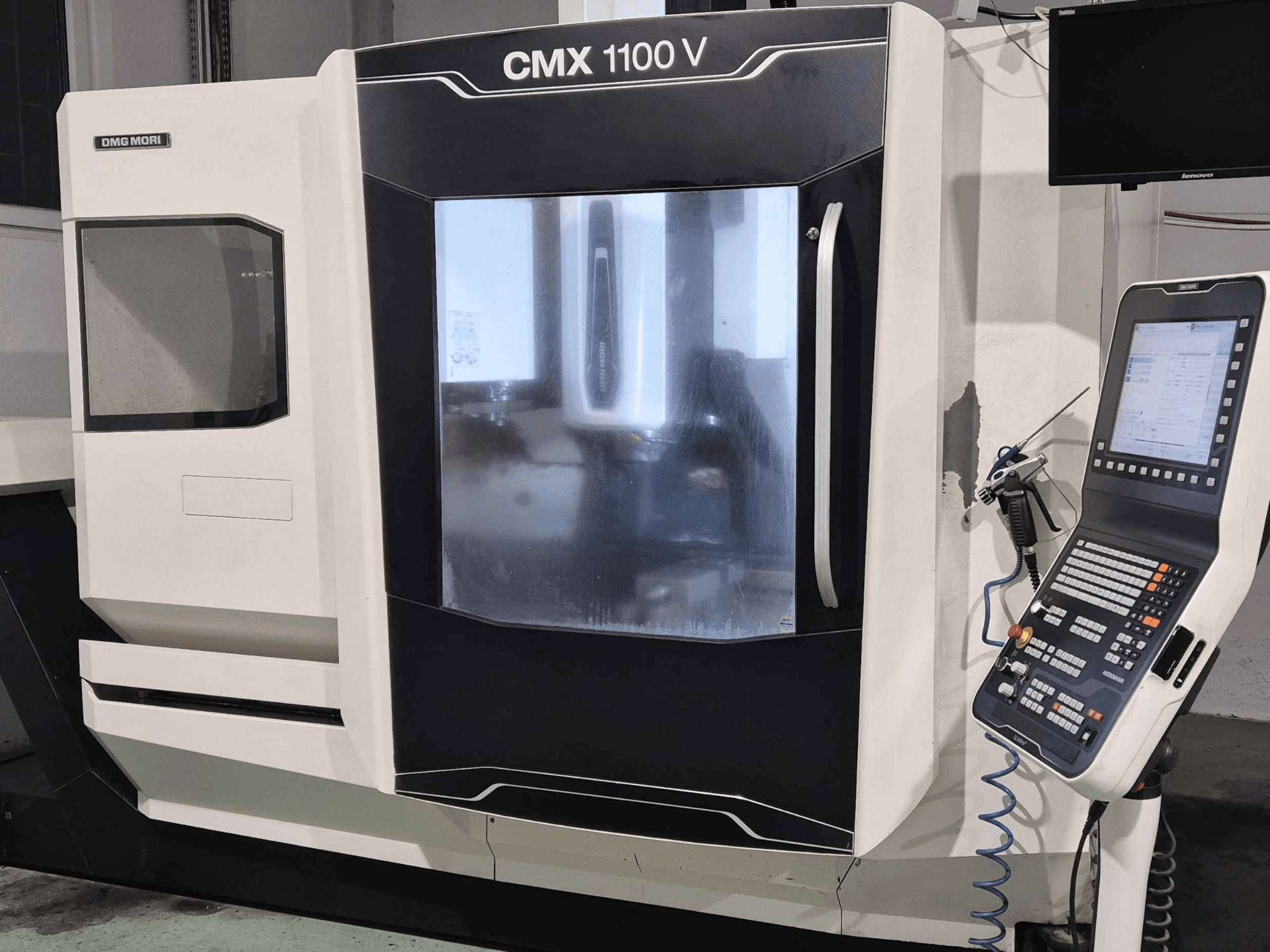 DMG Mori CMX 1100 V, vue de face de la machine CNC avec le panneau de commande, l'affichage numérique et le réglage du liquide de refroidissement visibles.