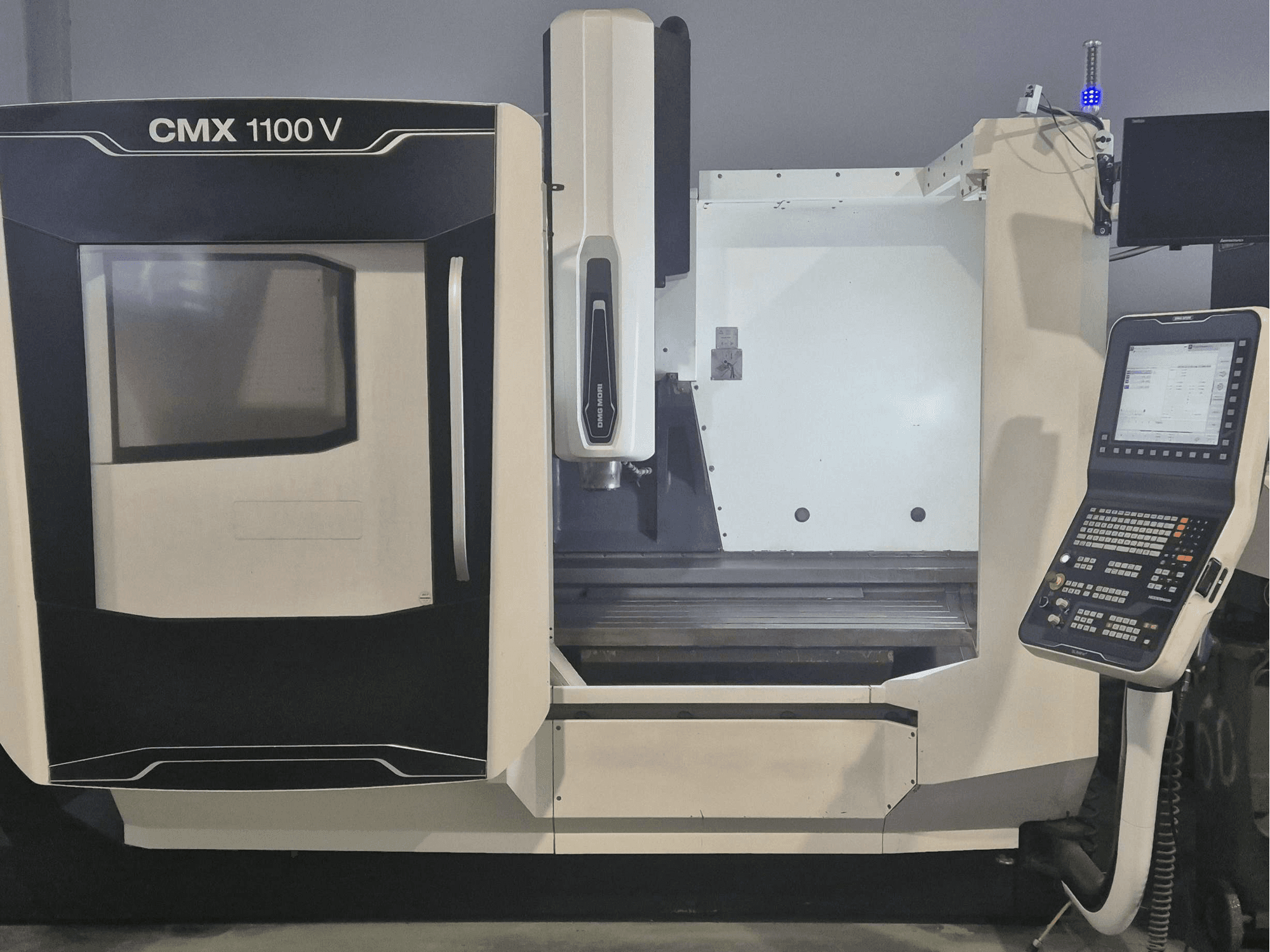 Centre d'usinage vertical DMG MORI CMX 1100 V, vue de face montrant le panneau de commande et le banc de la machine.