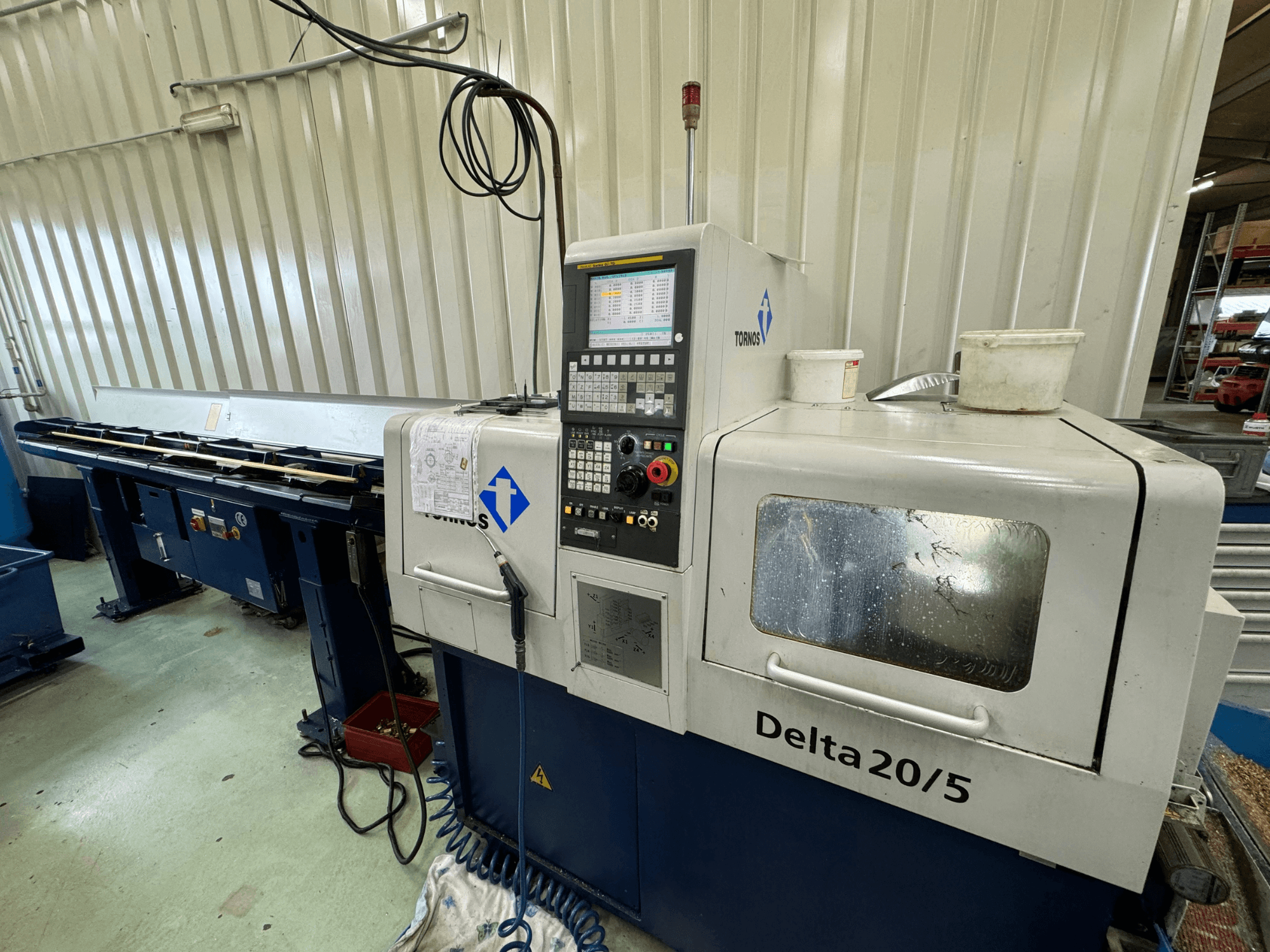 Machine CNC Torino Delta 20/5, vue de face, avec panneau de commande et espace de travail. Le verre est gravé et le câblage est visible.