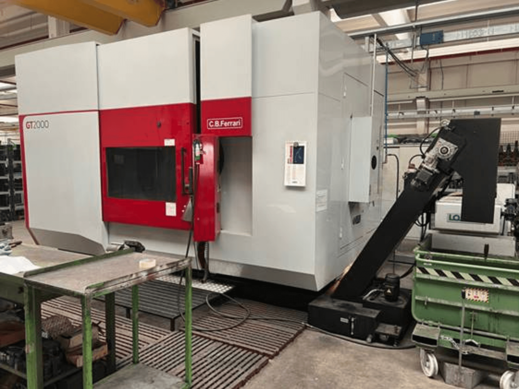 Fraiseuse C.B. Ferrari GT2000 vue de face, dotée d'un bras robotisé et d'un espace de travail industriel avec chariot vert.