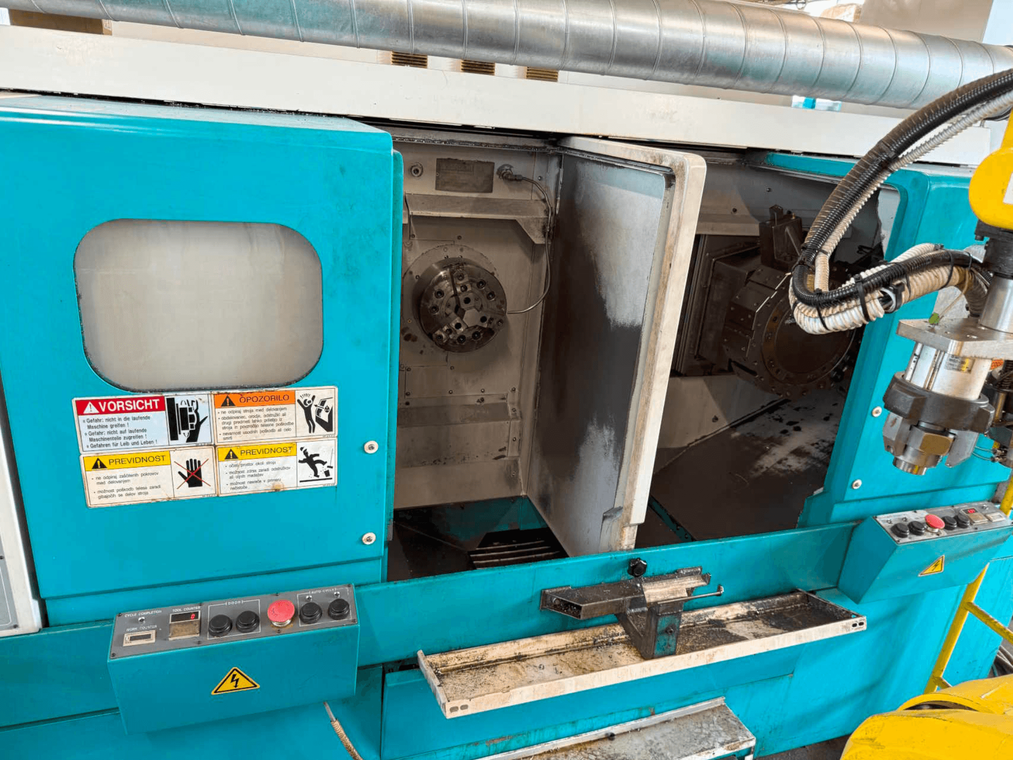 Tour horizontal DOOSAN H310T, vue de face montrant le panneau de commande et la zone de la broche avec les avertissements de sécurité.