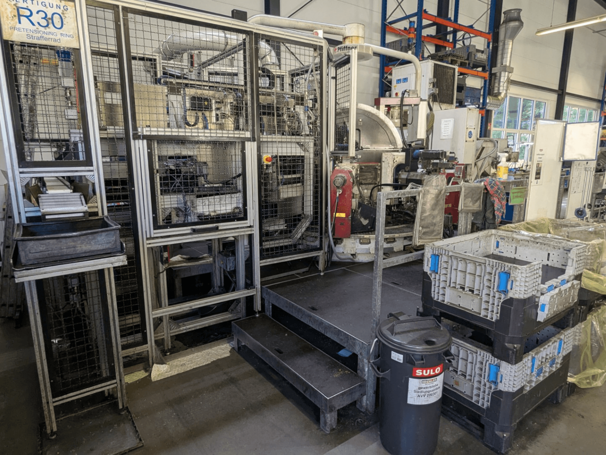 Machine-outil PFIFFNER HB 32/16 dans un atelier, vue de face montrant la zone de production avec des bacs et des barrières de sécurité.