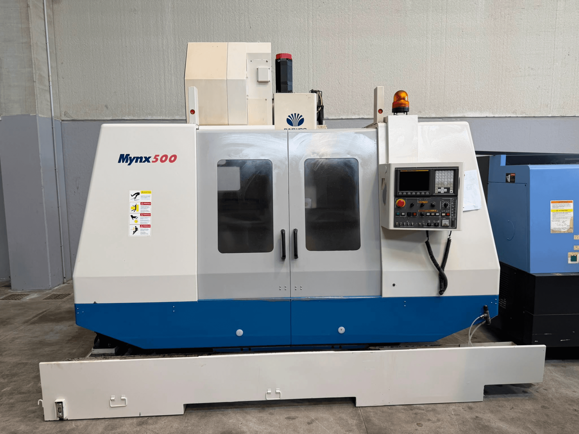 Centre d'usinage vertical DAEWOO MYNX 500, vue de face, avec panneau de commande, voyants de sécurité et portes d'accès transparentes.
