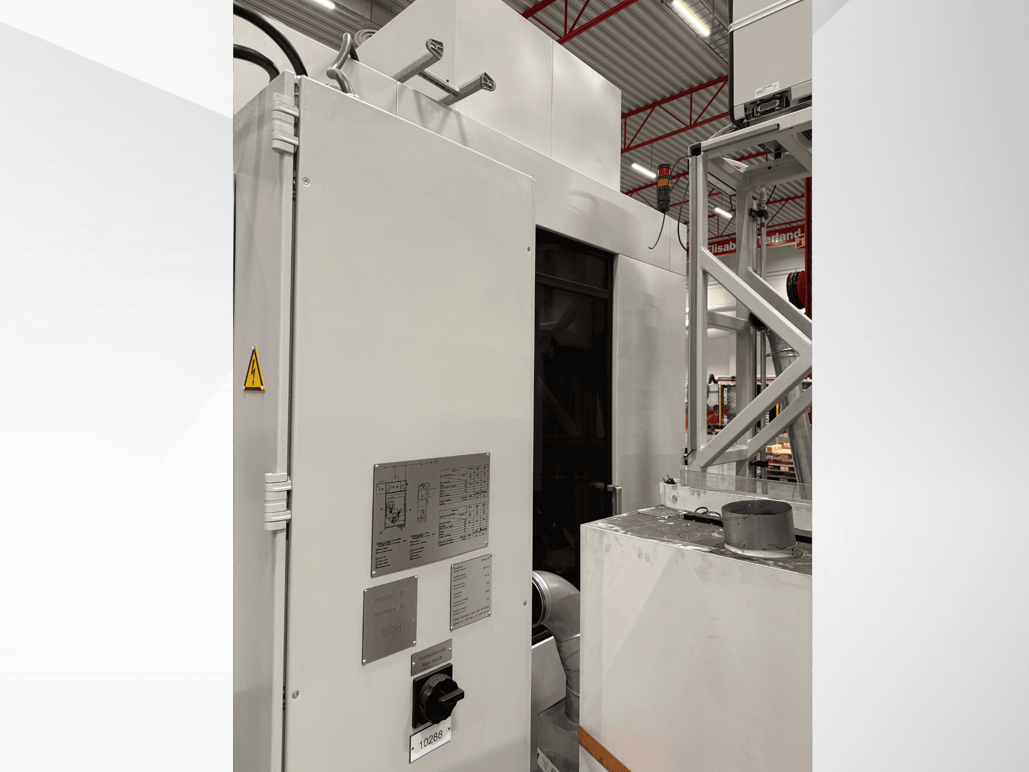 Vue latérale d'une machine industrielle blanche avec panneau de commande et étiquette d'avertissement, faisant partie d'un système automatisé.