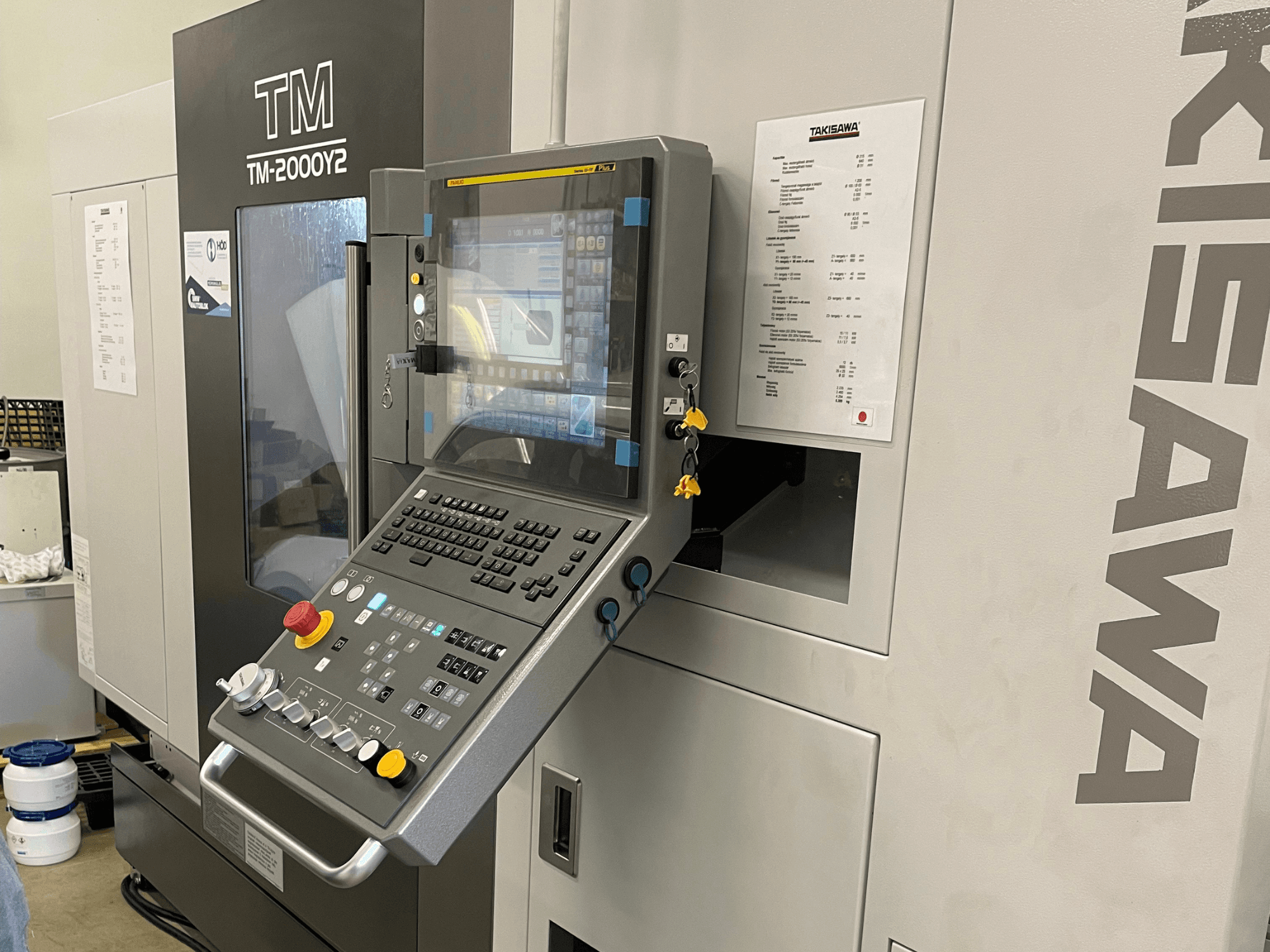 Panneau de commande du tour horizontal Takisawa TM-2000Y2 en vue de face, comportant un affichage numérique et des boutons de commande.