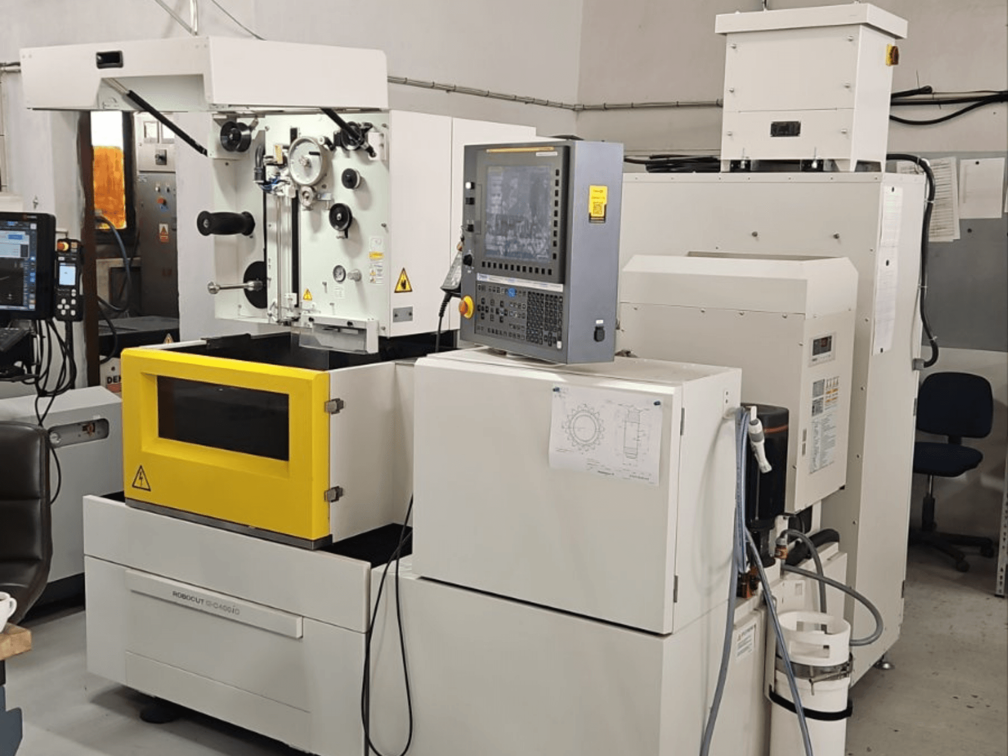 Machine d'électroérosion à fil FANUC Robocut alpha C400iC, vue de face montrant le panneau de commande et la chambre de travail jaune.