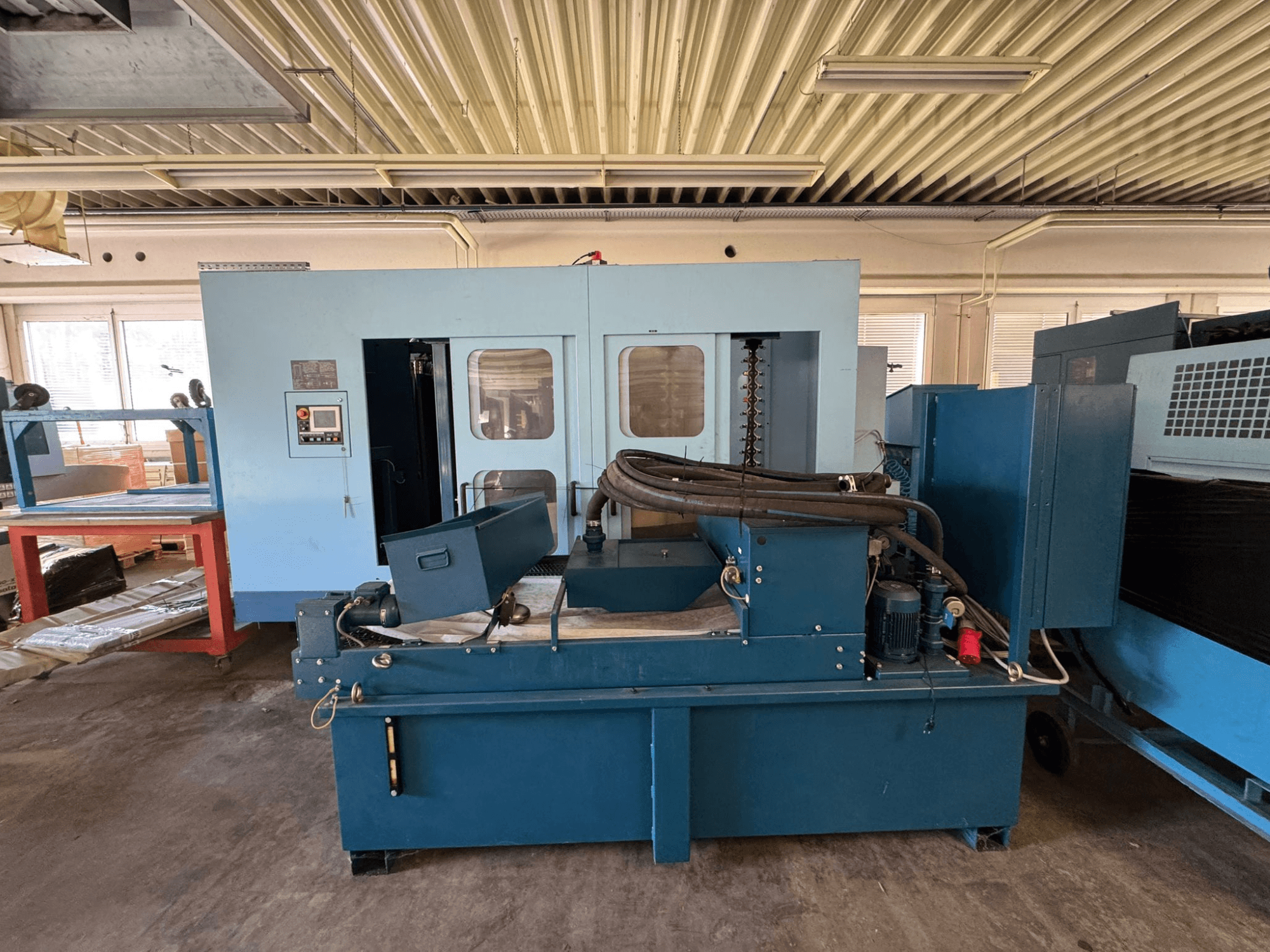 Centre d'usinage horizontal Matsuura H. Plus 405 de couleur bleue, vue de face, mettant en évidence le panneau de commande et les composants de la machine.