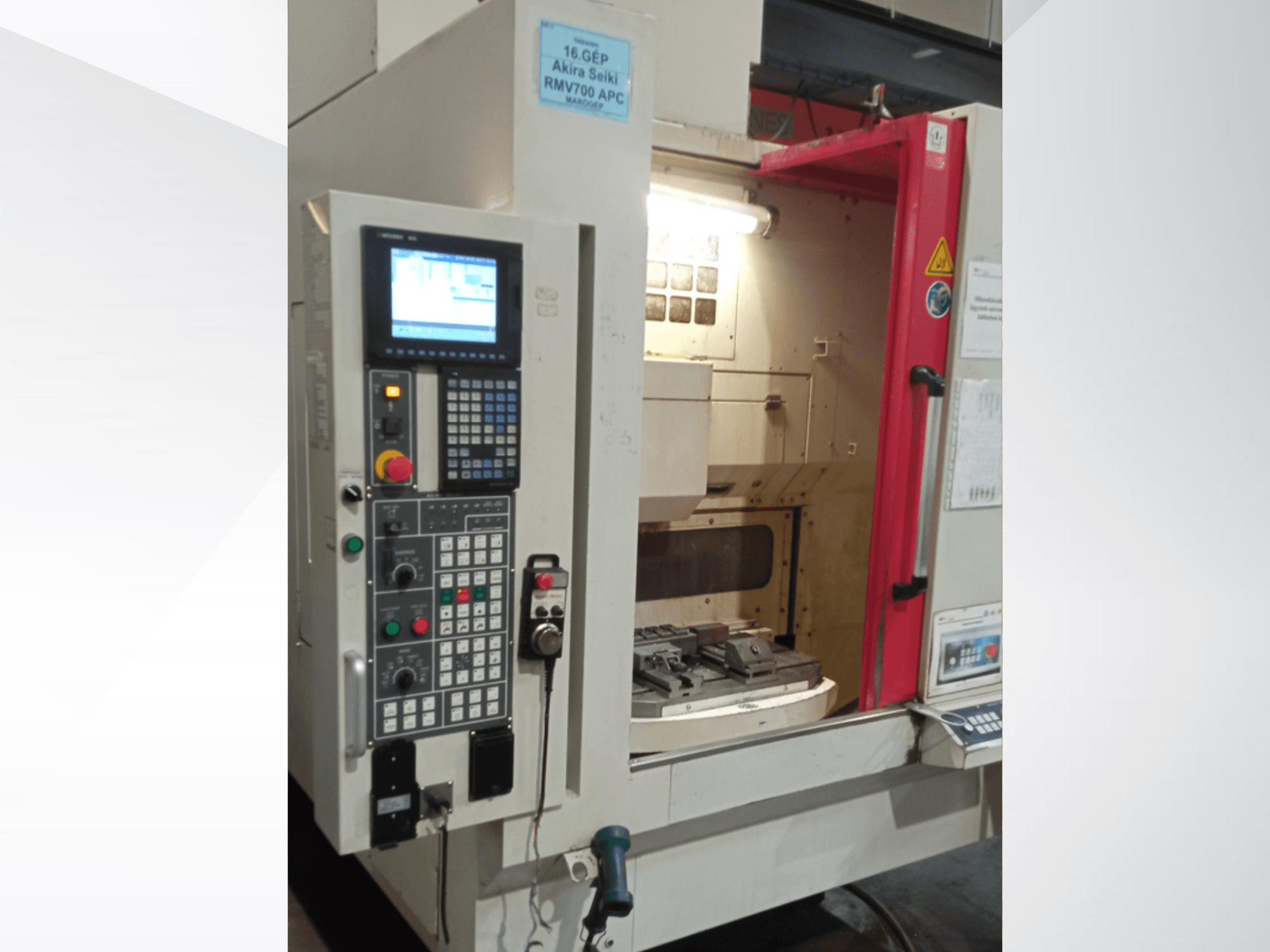 Vue de face du centre d'usinage vertical Akira Seiki RMV 700 APC, doté d'un panneau de commande numérique et d'une zone de travail avec outils.