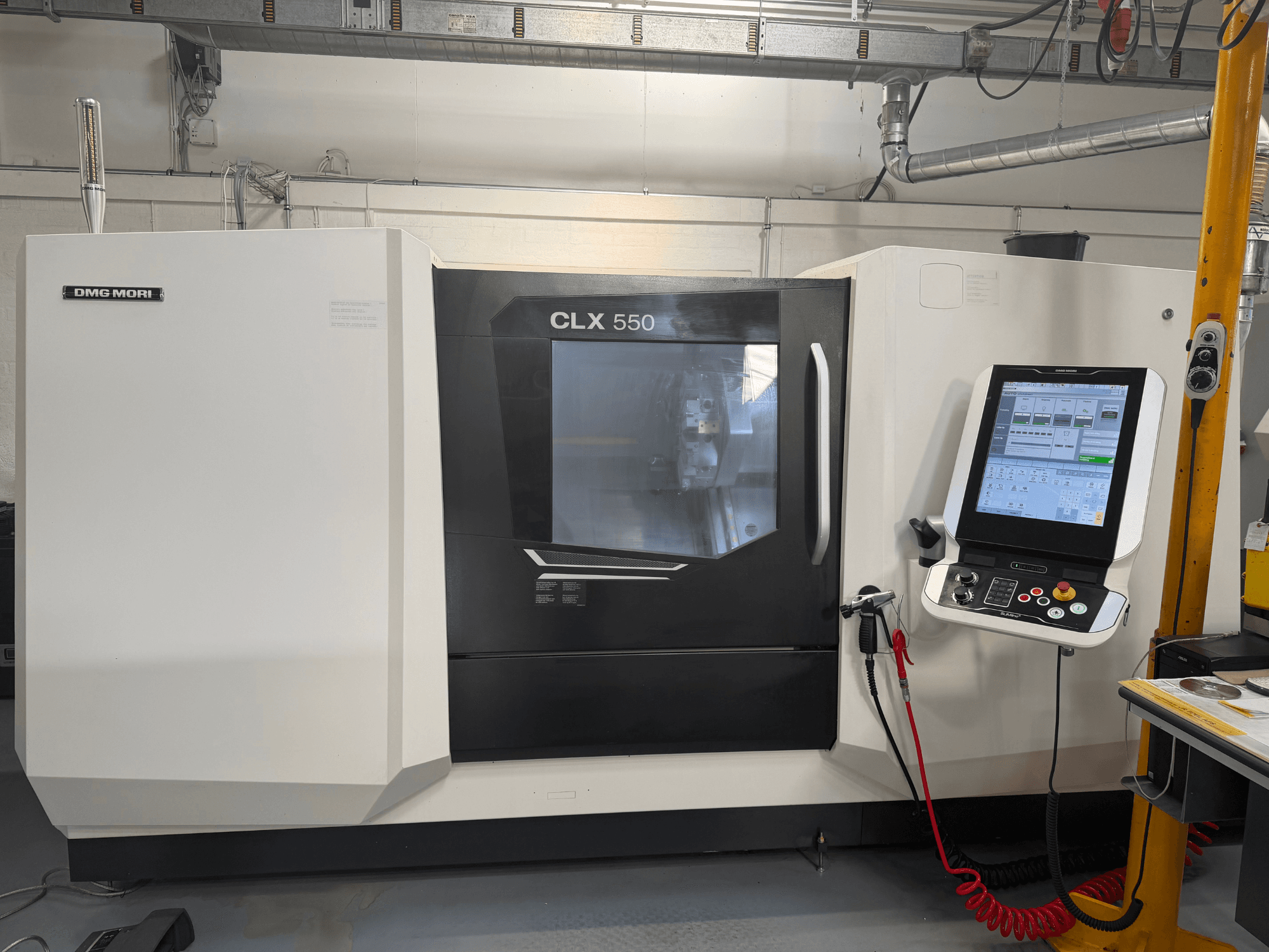 Tour horizontal DMG MORI CLX 550 V4, vue de face avec le panneau de commande et l'écran, mettant en avant ses fonctionnalités d'usinage avancées.