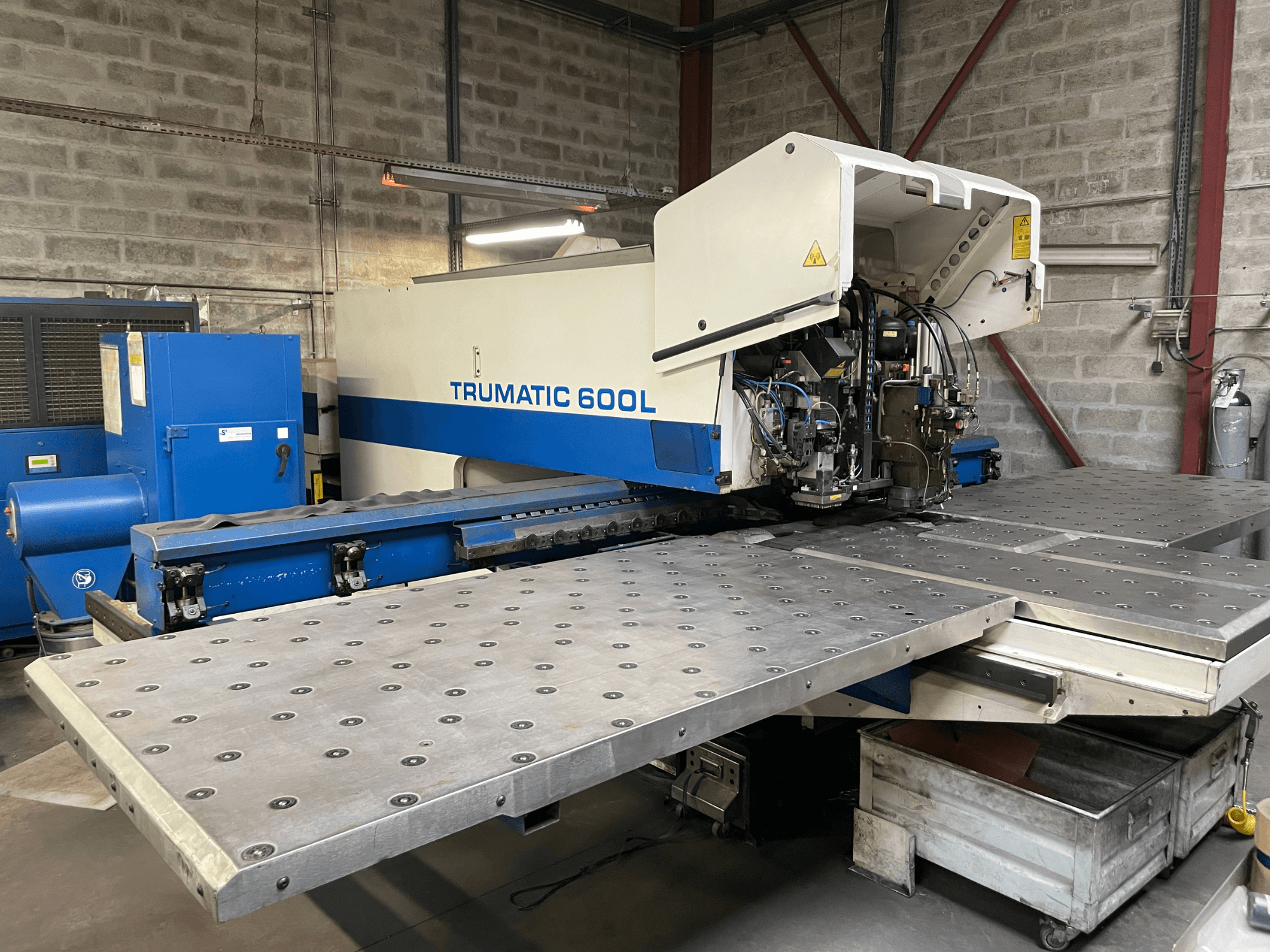 Machine de découpe laser CO2 TRUMPF TRUMATIC TC 600L, vue de face avec la table de découpe et le panneau de commande visibles.