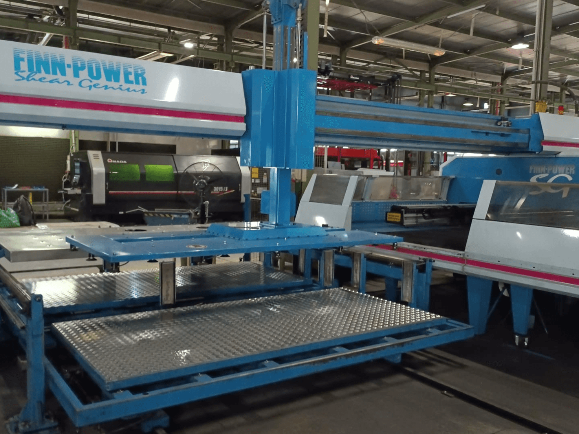 Vue de face de la poinçonneuse CNC « Shear Genius » SG6 de Finn-Power, mettant en évidence les tables métalliques et les caractéristiques structurelles.