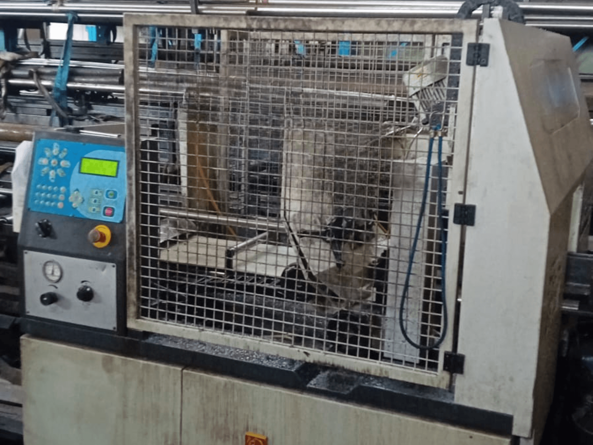 Scie à ruban à métaux Macc 381 AV, vue de face, montrant le panneau de commande, la cage de sécurité et les débris métalliques sur la base.