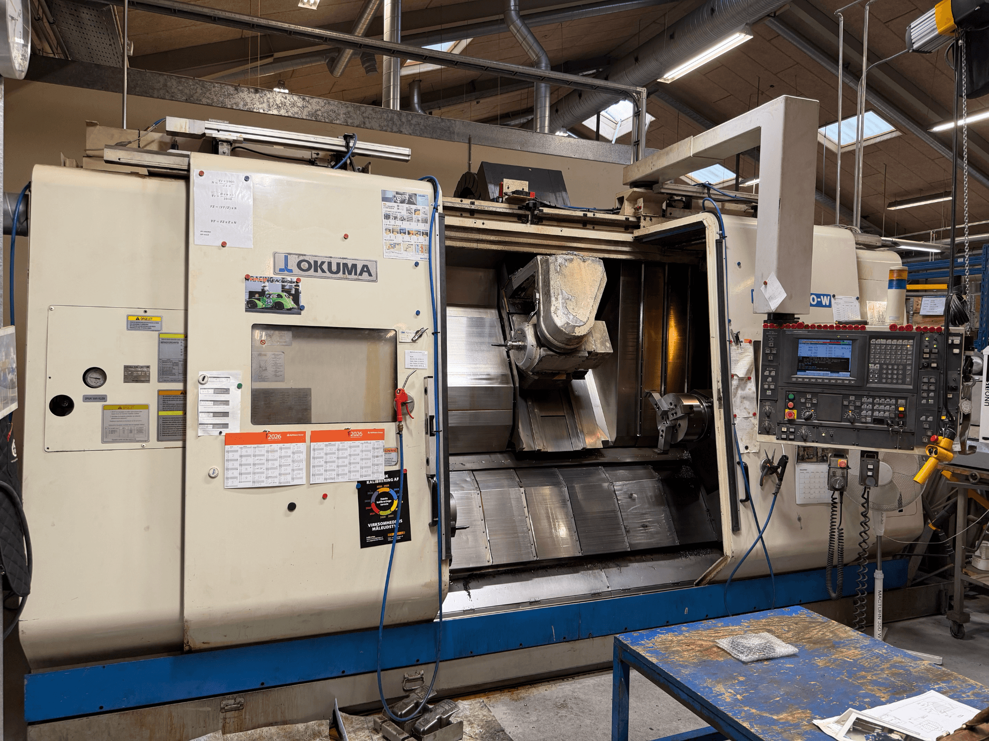 Centre de tournage-fraisage Okuma MacTurn350-W, vue de face mettant en évidence le panneau de commande et l'accès dégagé à la zone d'usinage.