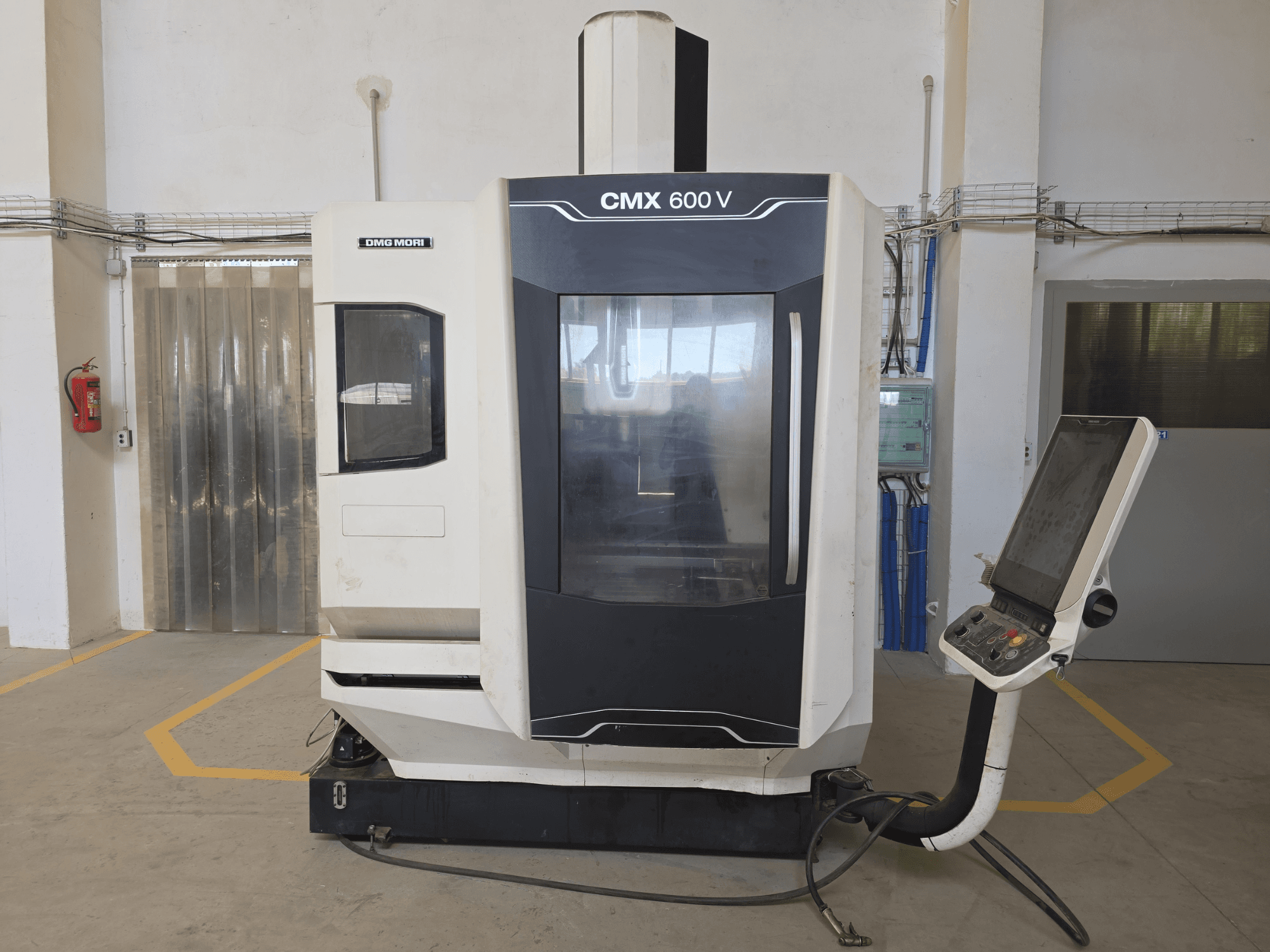 Centre d'usinage vertical DMG MORI CMX 600 V, vue de face, présentant le panneau de commande et la grande fenêtre transparente.