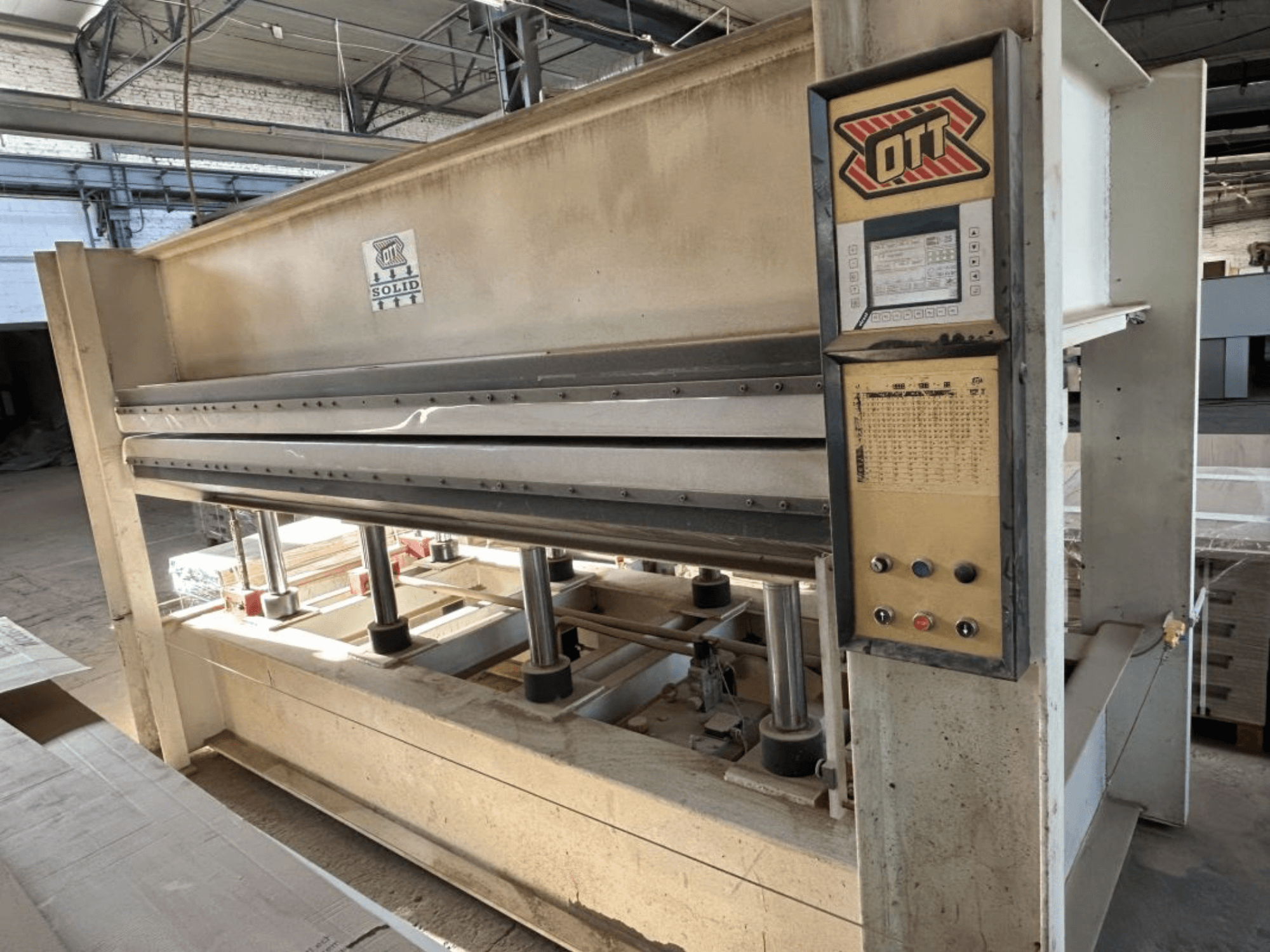 Vue de face de la presse à laminer OTT SOLID 16-32, montrant le panneau de commande et les composants hydrauliques.