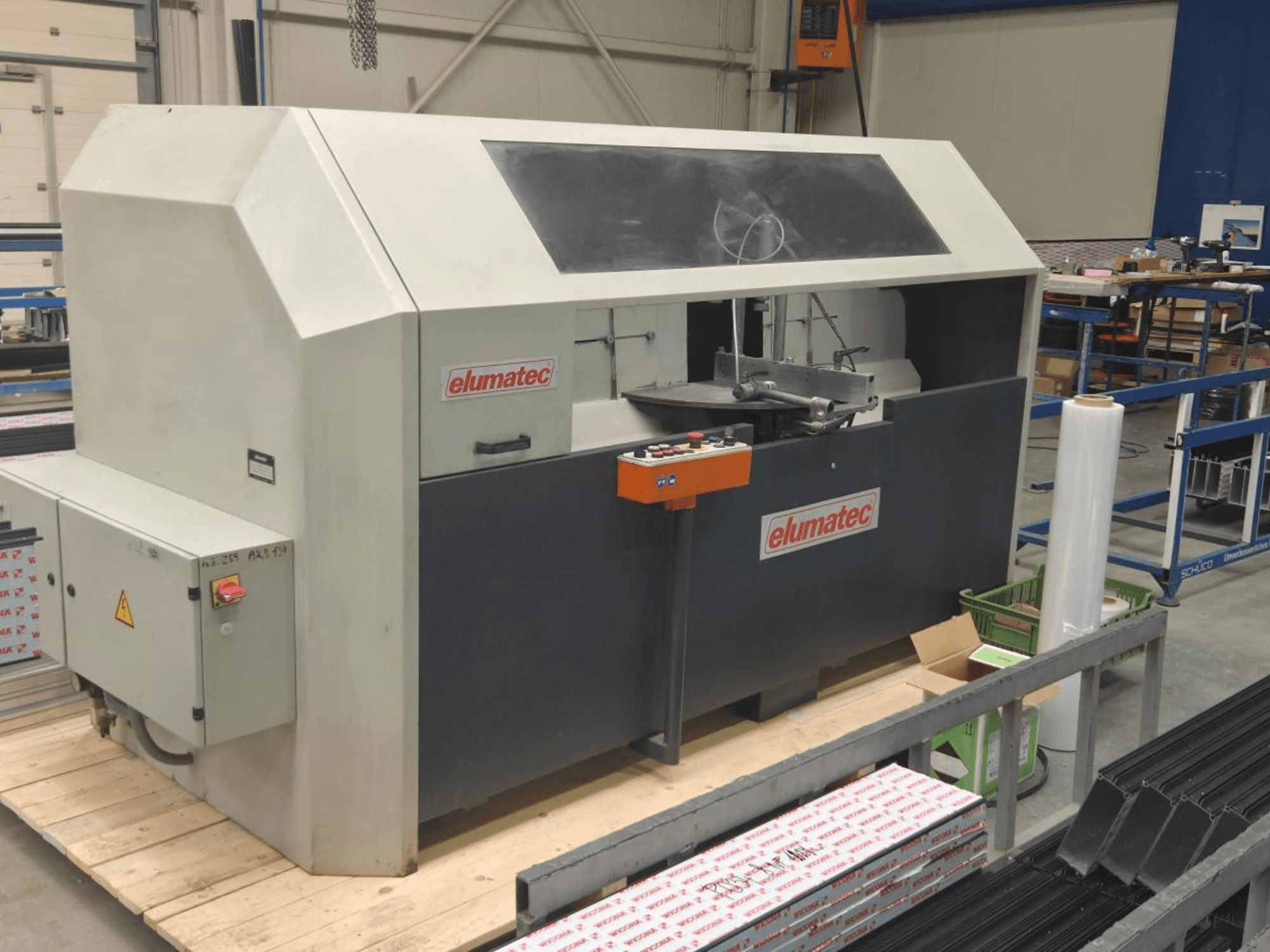 Scie circulaire à métaux Elumatec AKS 134, vue de face, présentant le panneau de commande et la zone de coupe sur une plate-forme en bois.