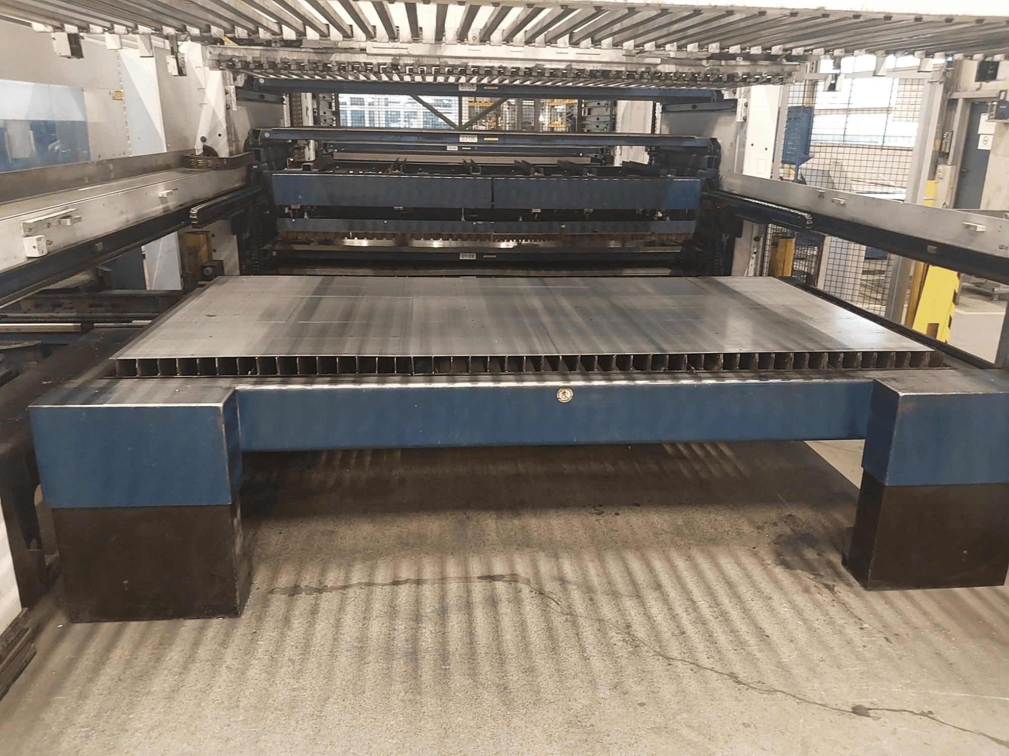 Vue avant de la machine de découpe laser CO2 TruLaser 3030 L20 de TRUMPF avec un grand lit de découpe et une structure de support.
