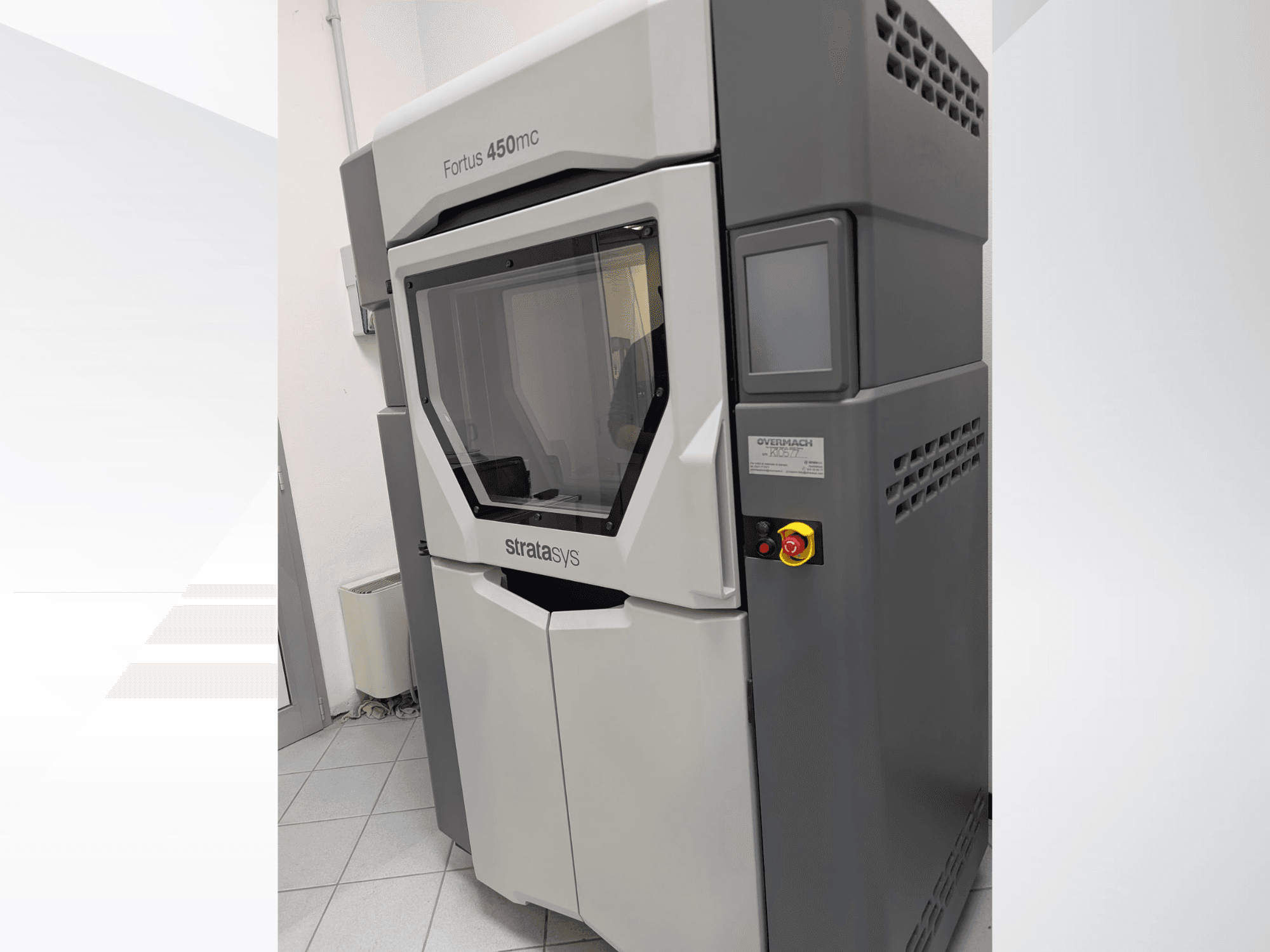 Imprimante 3D en plastique Fortus 450mc présentée en vue latérale, avec un panneau avant transparent et des boutons de commande sur le côté.