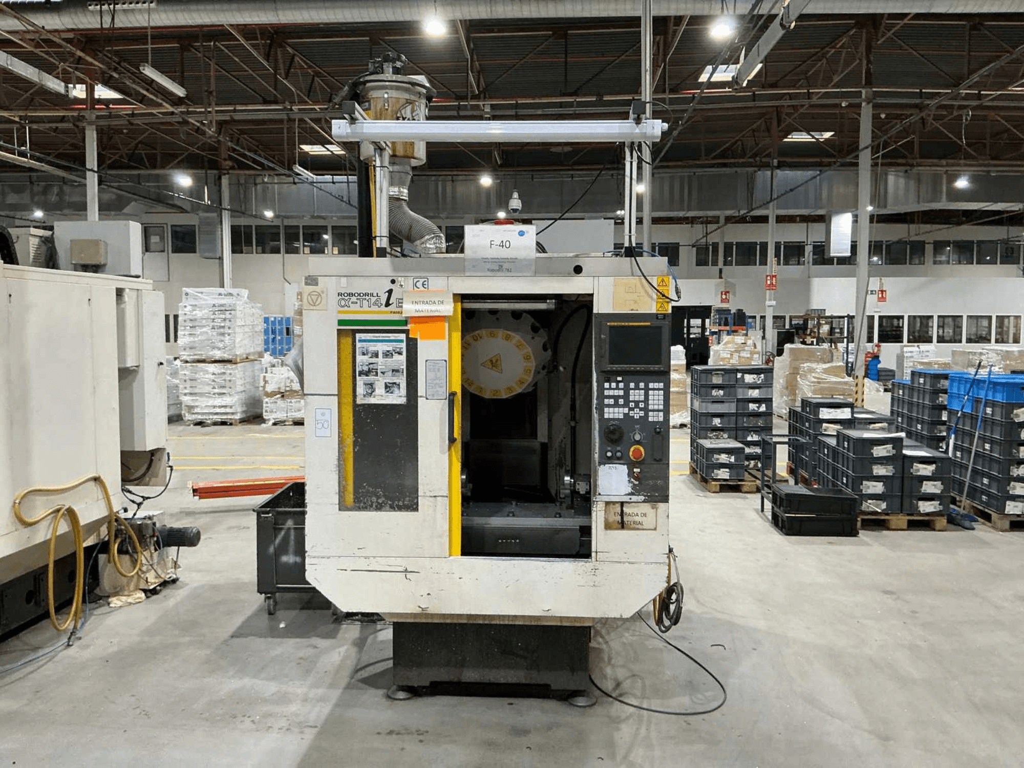 Centre d'usinage vertical FANUC ROBODRILL α-T14iB dans une usine, vue de face montrant le panneau de commande et le porte-outil.