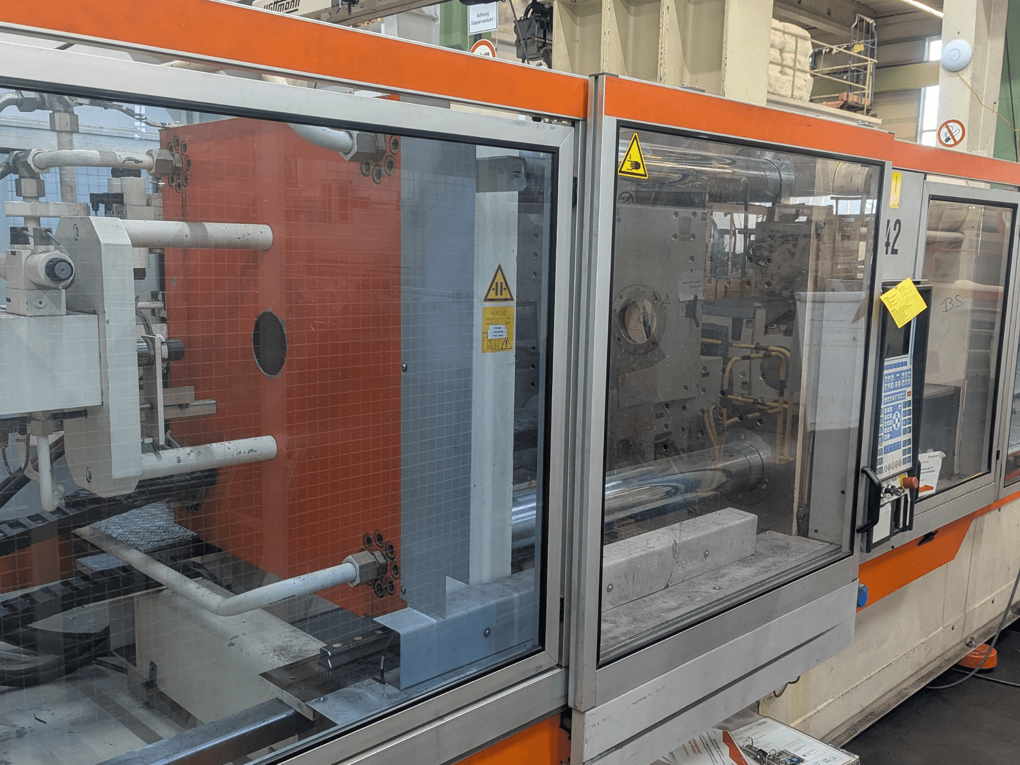 Vue de face d'une presse à injecter hydraulique DEMAG SYSTEC 80/420-310 avec panneau de commande et composants de la machine visibles.