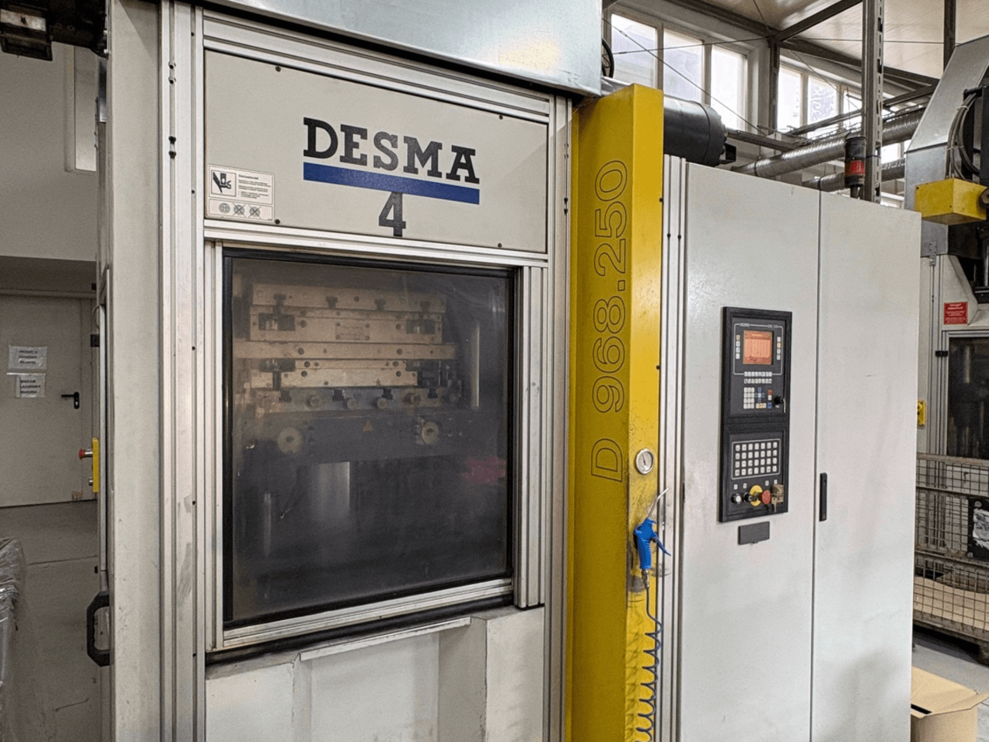 Machine de moulage par injection verticale Kloeckner Desma 968.250, vue de face montrant le panneau de commande et les détails de la machine.