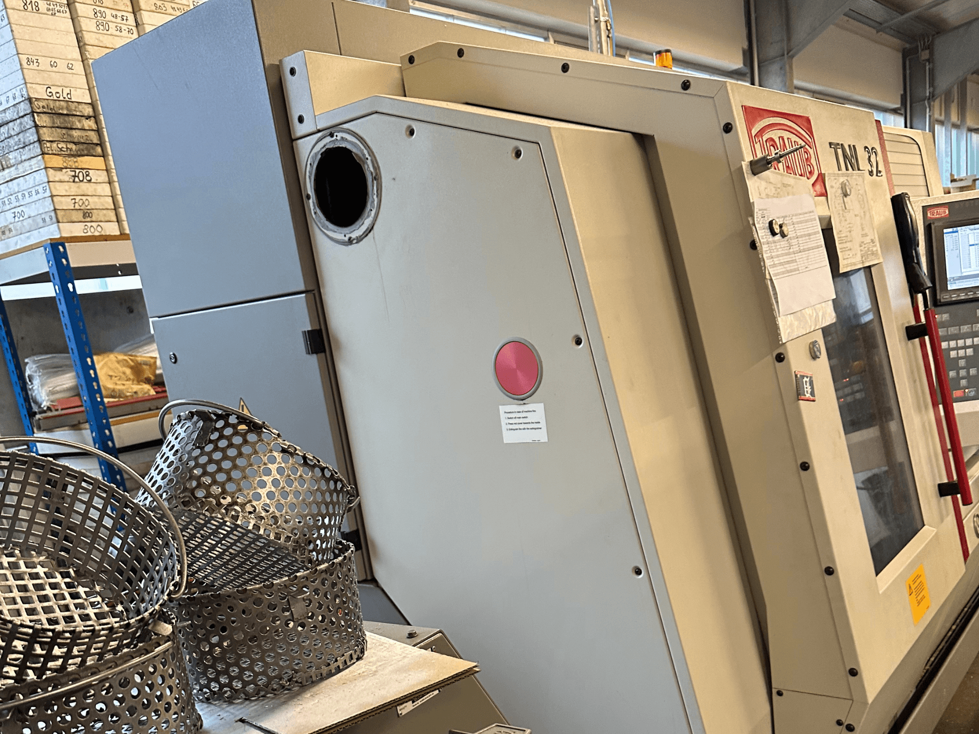 Tour de type suisse TRAUB TNL 32 P vu de profil, avec des paniers d'usine visibles au premier plan.