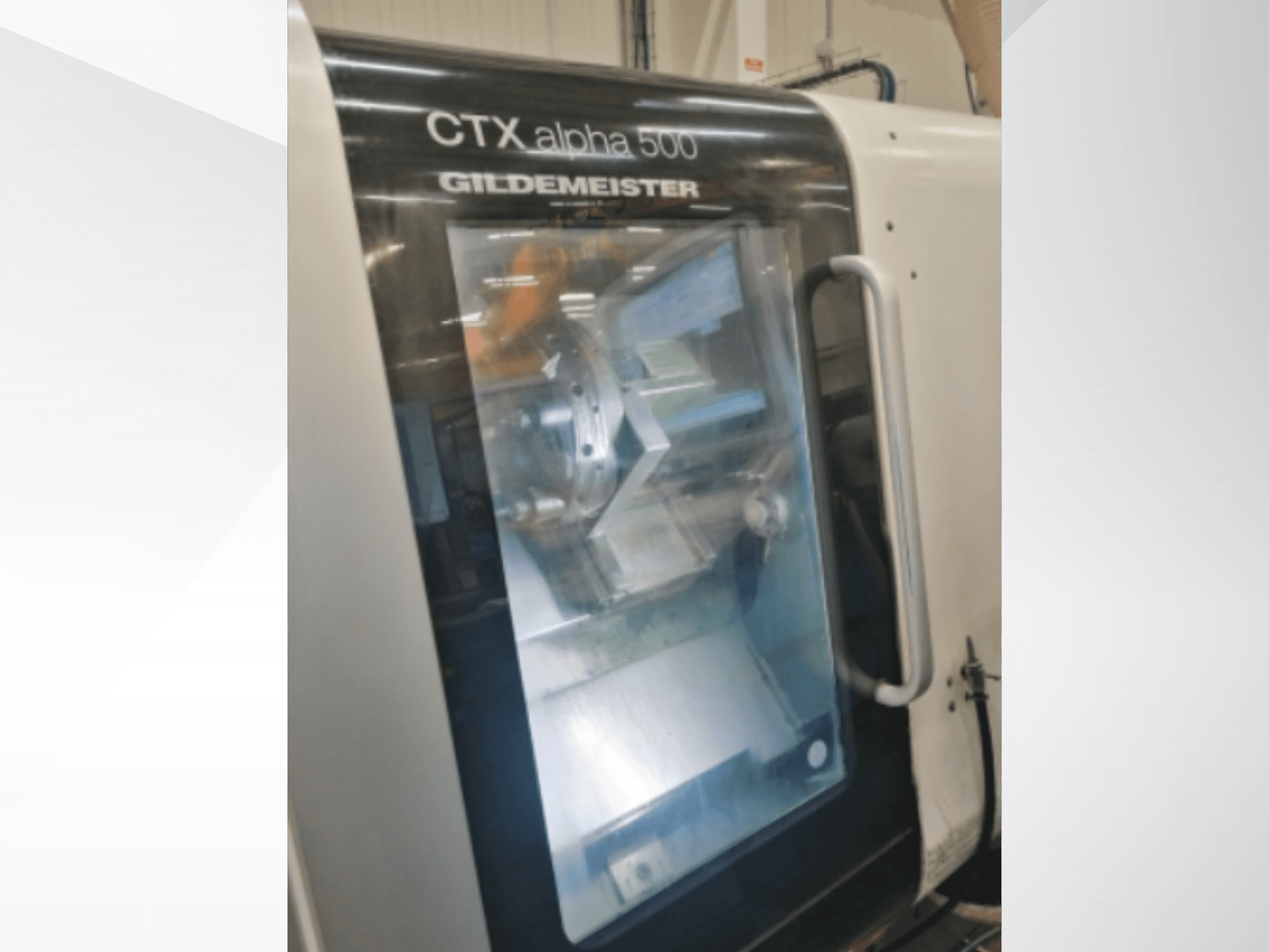 Machine CNC CTX alpha 500 Gildemeister, vue de face, montrant la broche et la zone d'usinage à travers la porte vitrée.