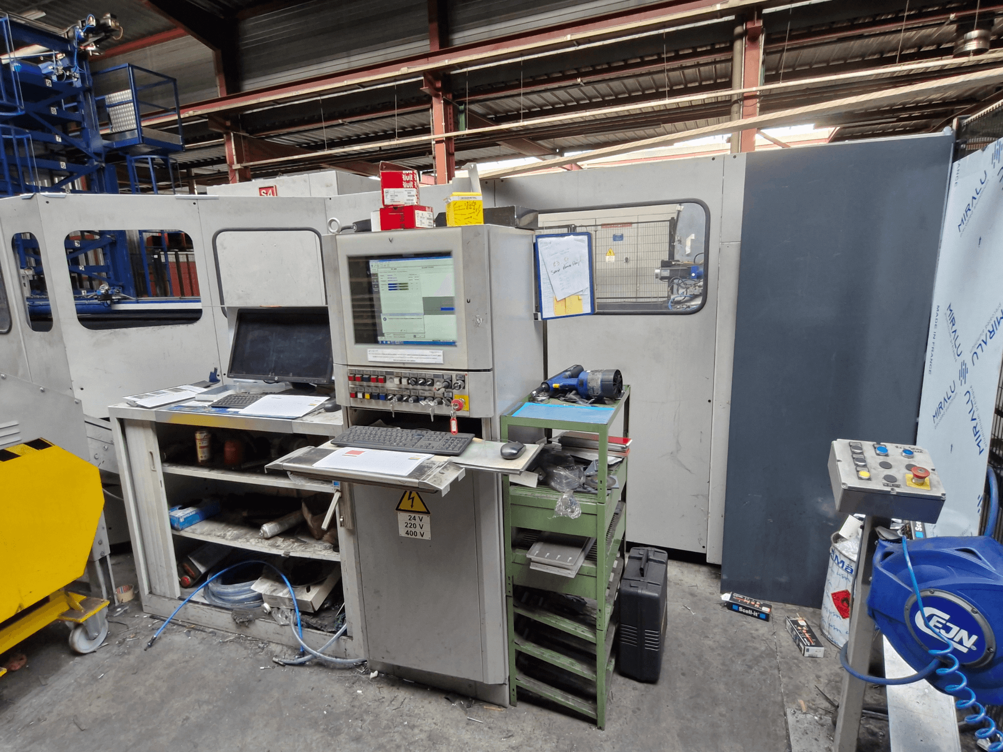 Poinçonneuse CNC Salvagnini S4-40 dans un atelier, comprenant un panneau de commande avec des moniteurs et des outils, vue de face.