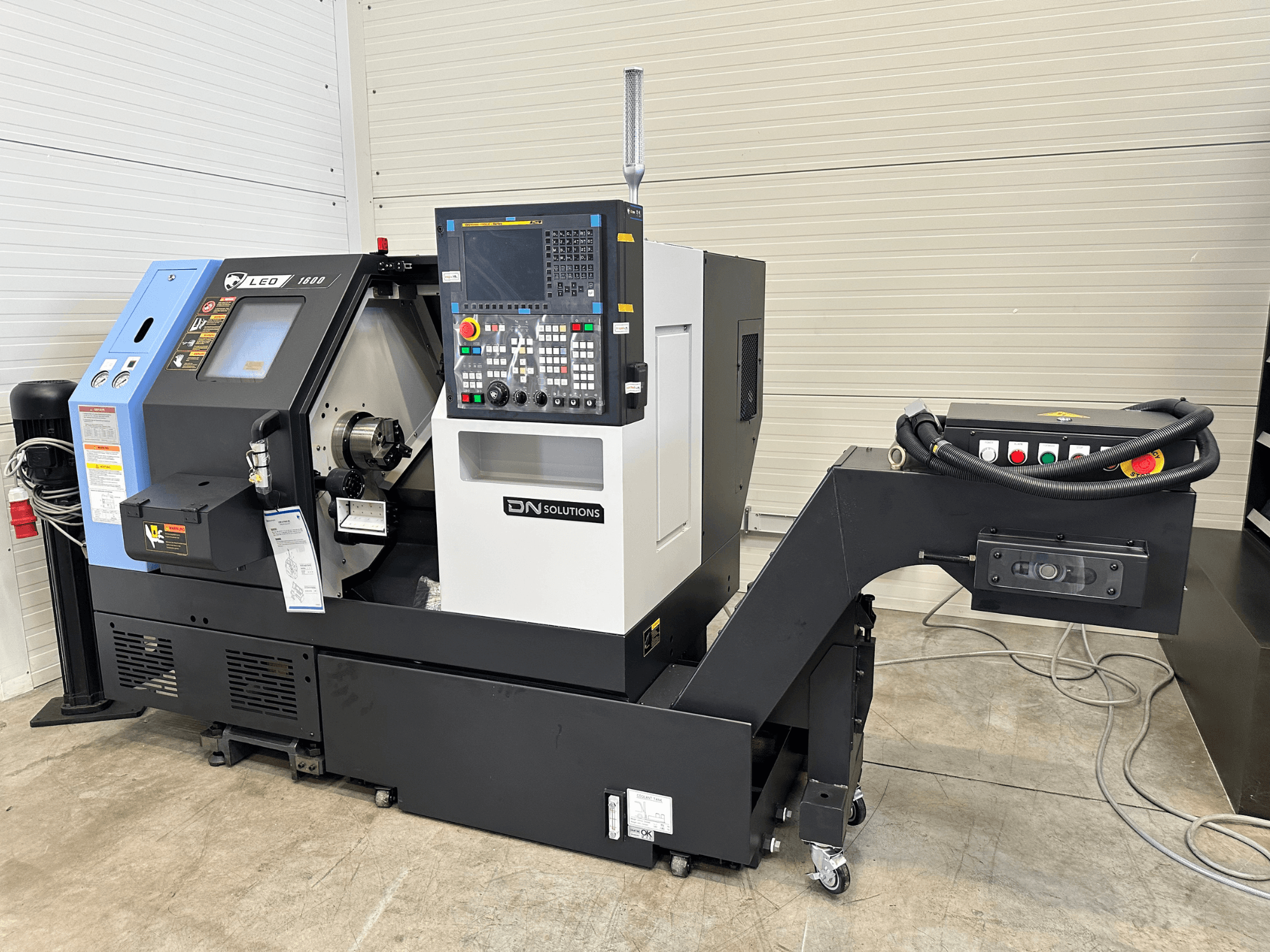 Vue de face du centre de tournage-fraisage Leo 1600 de DN SOLUTIONS, doté d'un panneau de commande numérique et d'un porte-outils, sur une base noire.